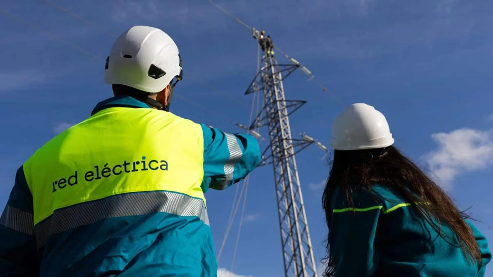 Técnicos de Red Eléctrica inspeccionando una torre de transmisión eléctrica