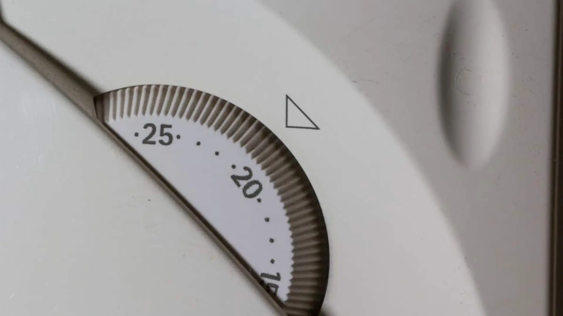 Detalle de un termostato analógico marcando la temperatura de calefacción doméstica