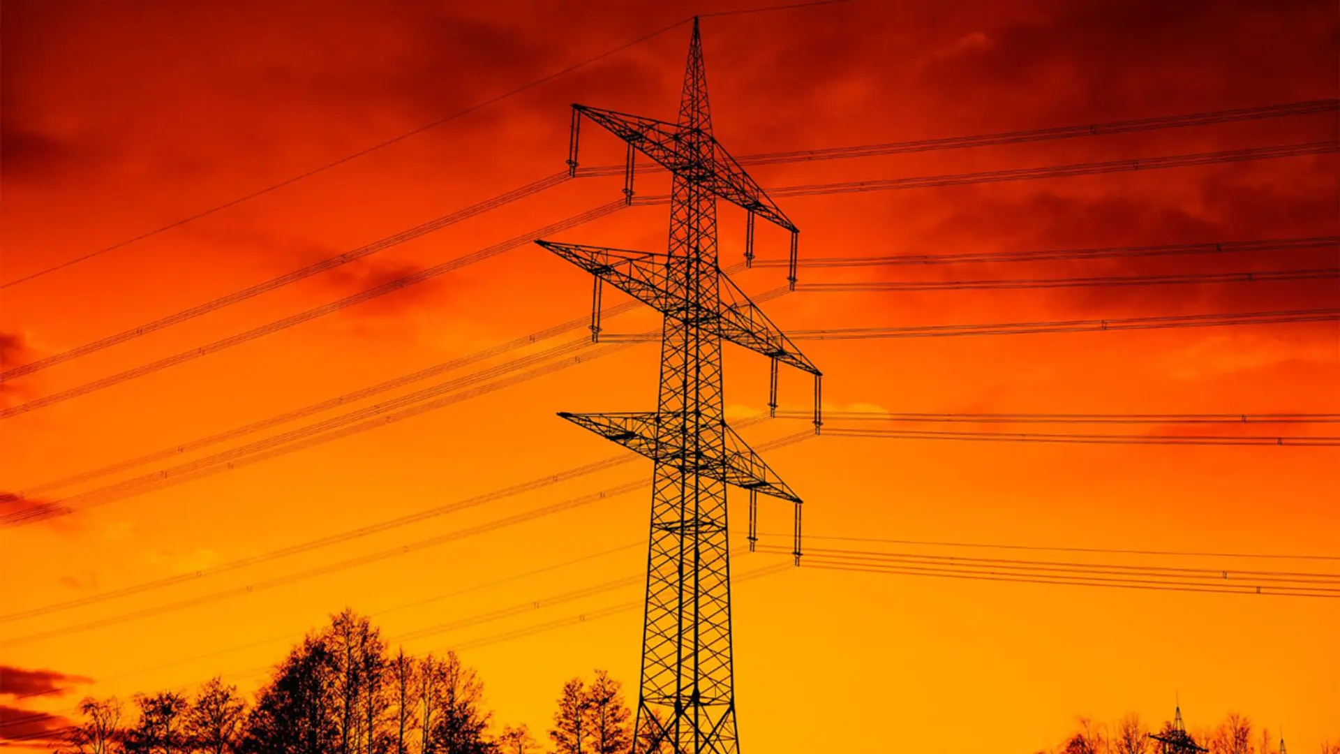 CNMC, Gobierno y eléctricas coinciden: el gran apagón se podía haber evitado Torre de alta tensión con líneas eléctricas al atardecer con cielo naranja intenso.