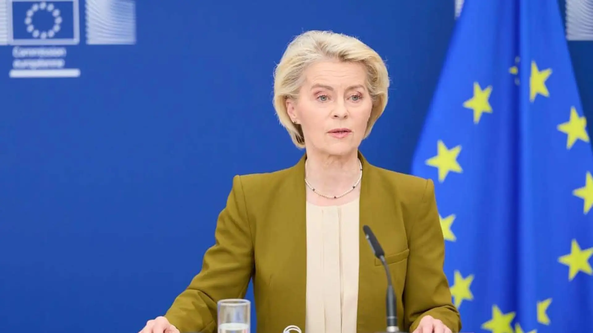 Ursula von der Leyen hablando en una rueda de prensa con banderas de la Unión Europea al fondo