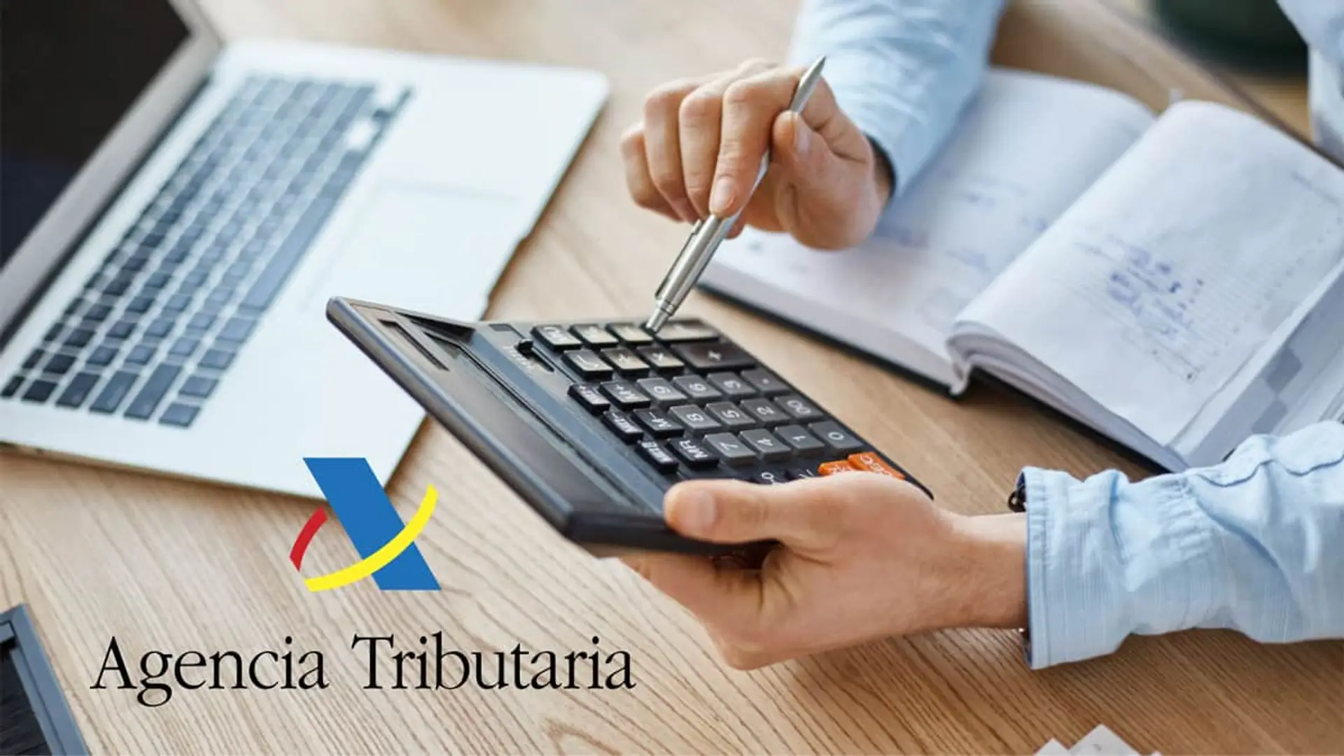 Persona usando una calculadora junto al logo de la Agencia Tributaria para realizar la Declaracion de la Renta.