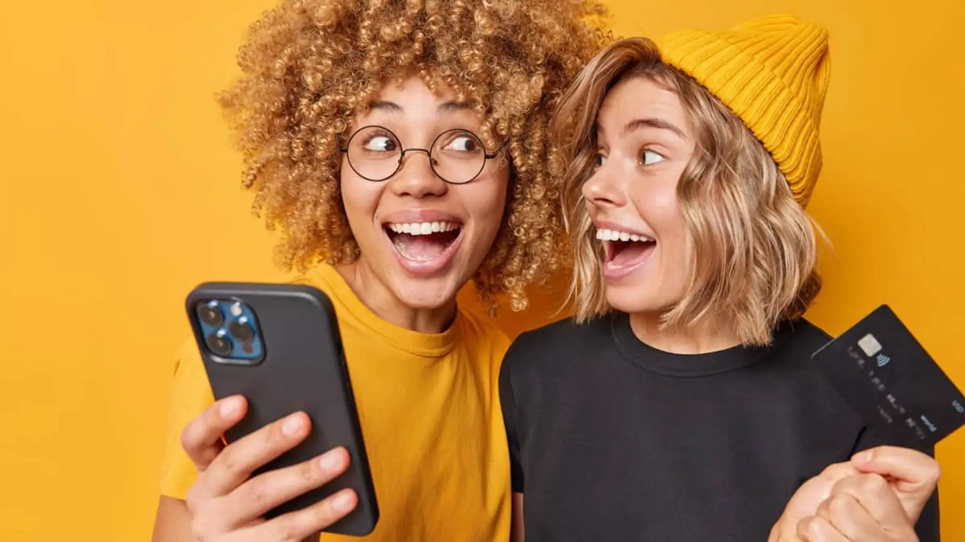 Jóvenes celebrando una compra online por la que han recibido cashback en su tarjeta de crédito.