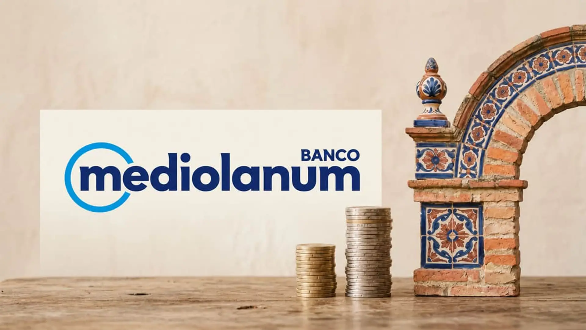 Logo de Banco Mediolanum junto a dos pilas de monedas y un arco de azulejos de estilo andaluz