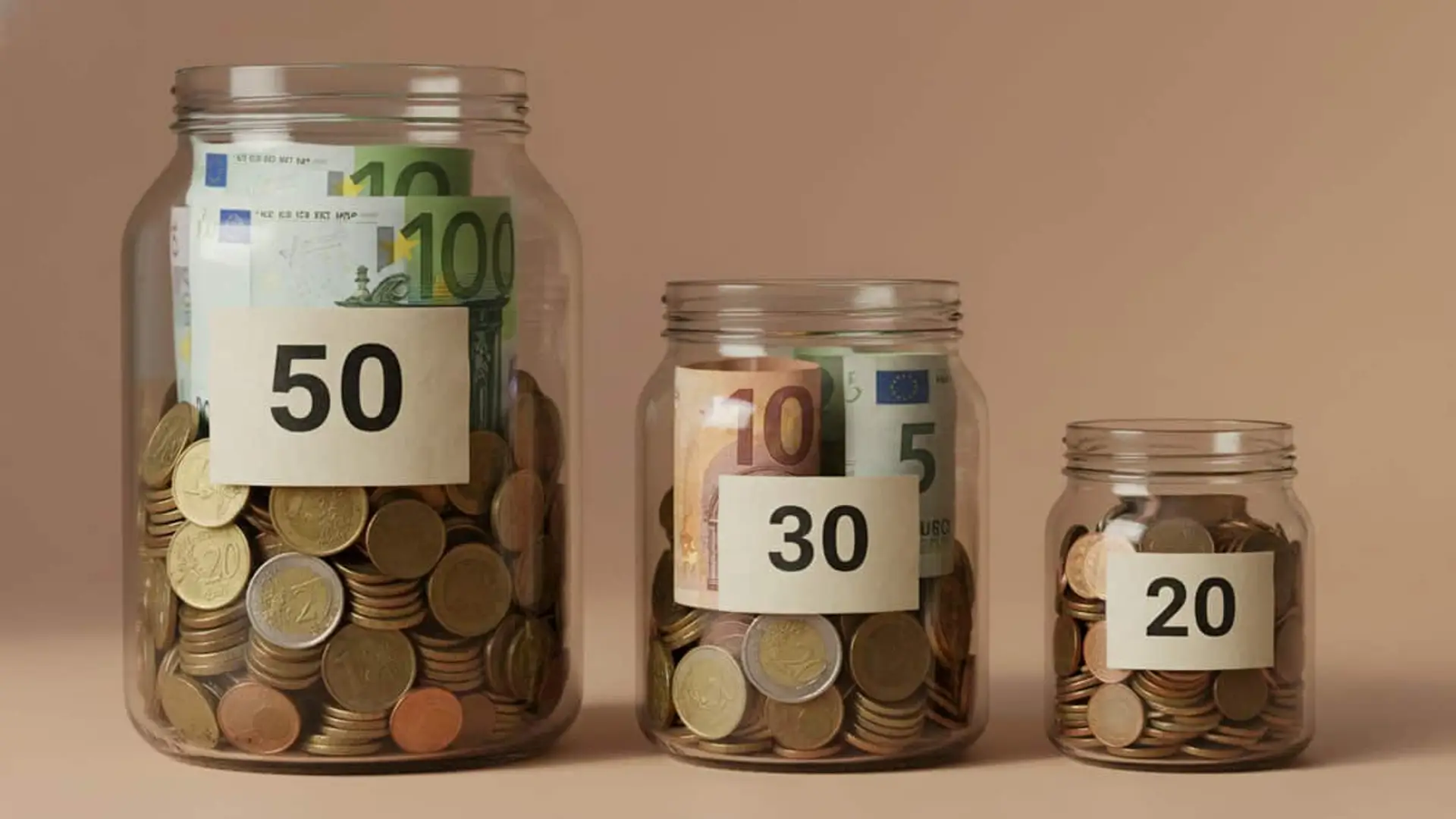 Tres botes de cristal llenos de monedas y billetes de euro, etiquetados con las cantidades 50, 30 y 20.