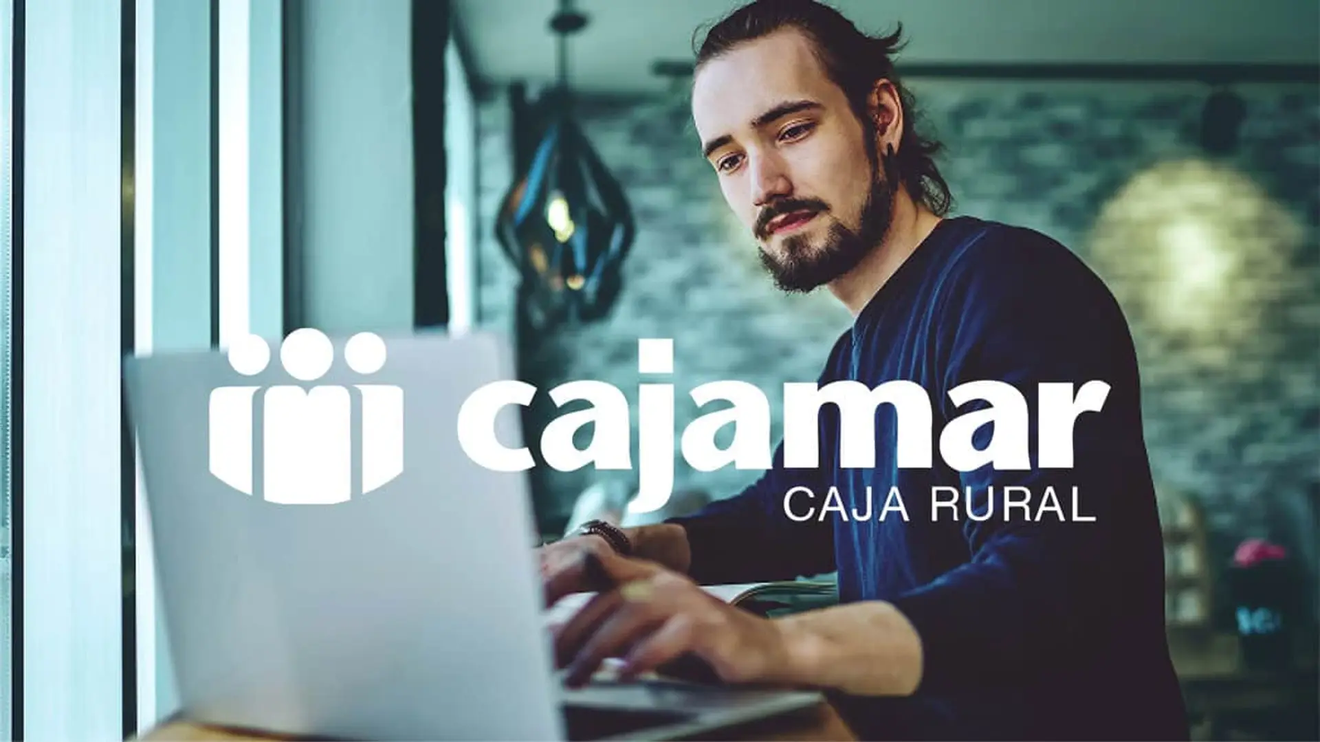 Cajamar estrena cuenta remunerada al 3% con hasta 750€ de regalo: una vía por ahorrar y otra por tu nómina Usuario frente a un portátil junto al logotipo de Cajamar para representar el acceso a servicios de banca online y digital.