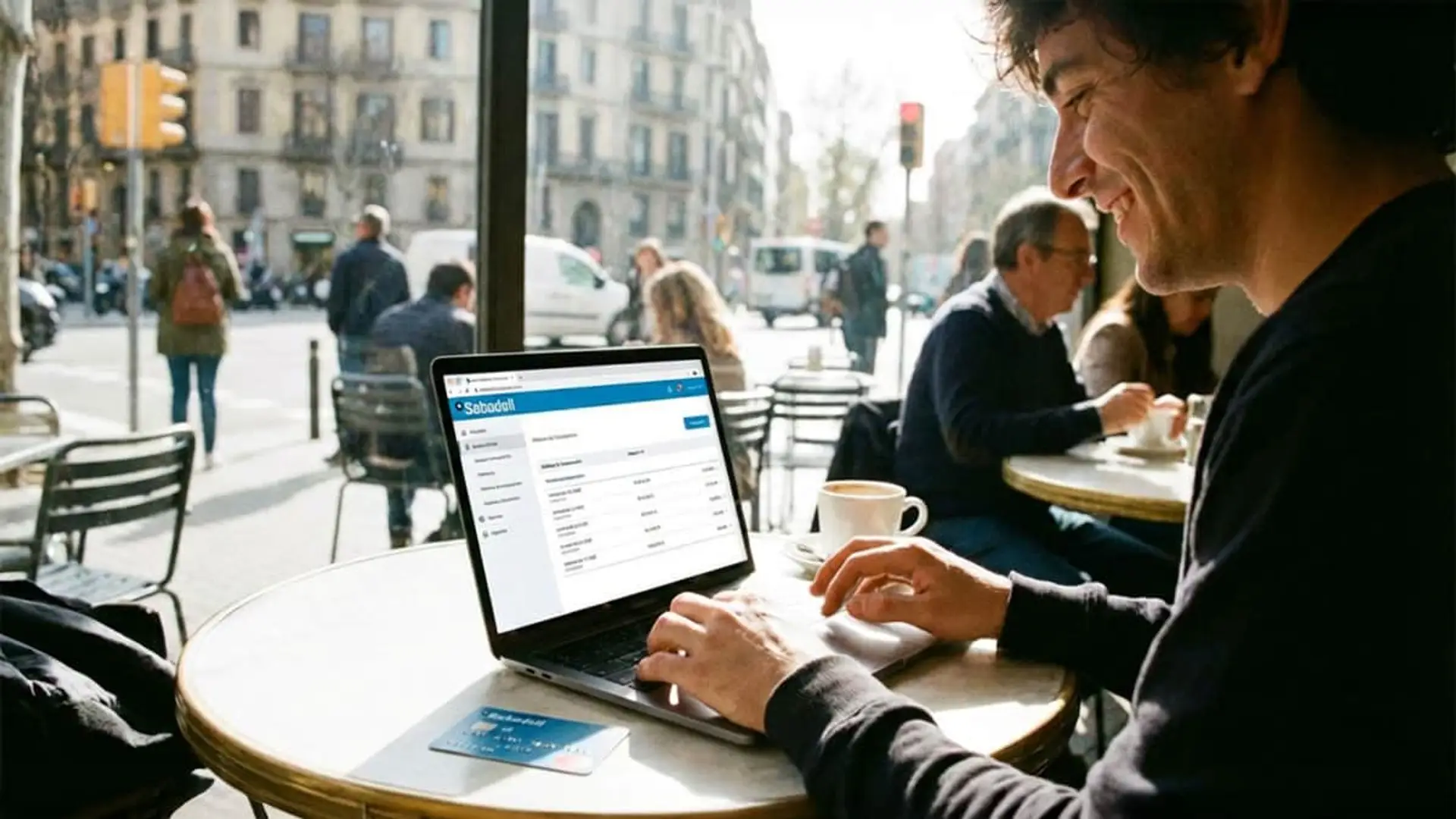 Banco Sabadell termina hoy su promoción estrella: hasta 1.650€ con su cuenta online remunerada Hombre joven gestionando su cuenta del Banco Sabadell con portátil en terraza de cafetería.