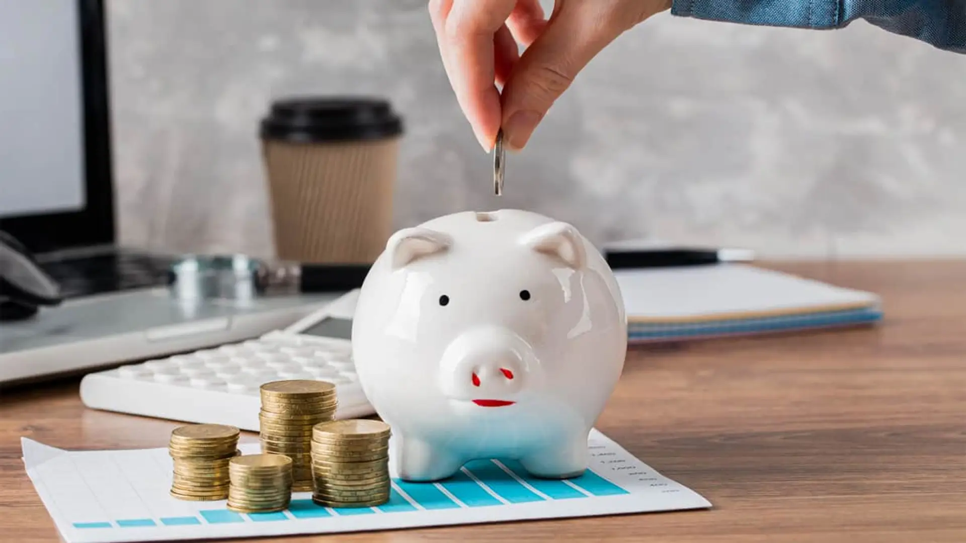 Alianza Caser-EBN Banco: depósito al 2,85% TAE por traspasar un plan de pensiones Mano introduciendo una moneda en una hucha para ahorrar, una metáfora de contratar un depósito bancario a plazo fijo.