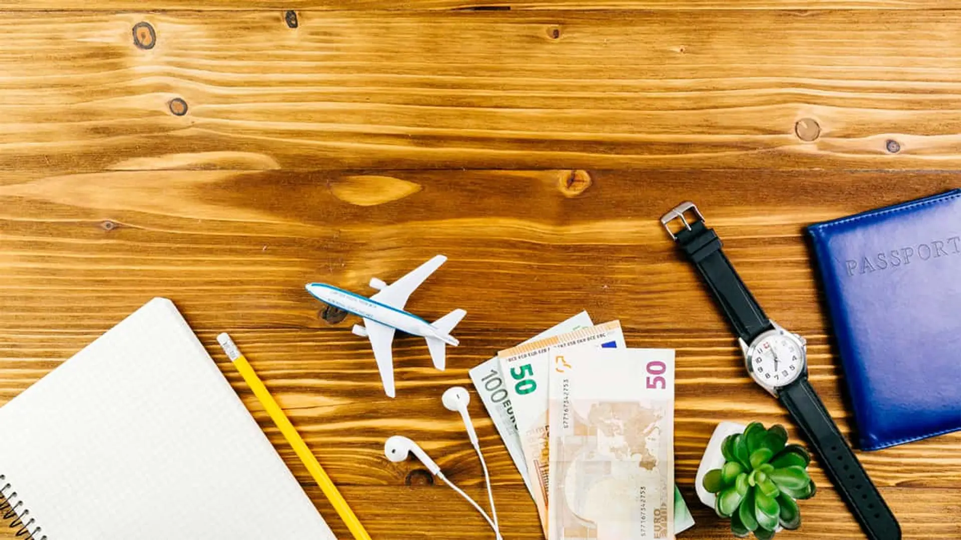 Dinero, pasaporte y reloj en preparativos de viaje.