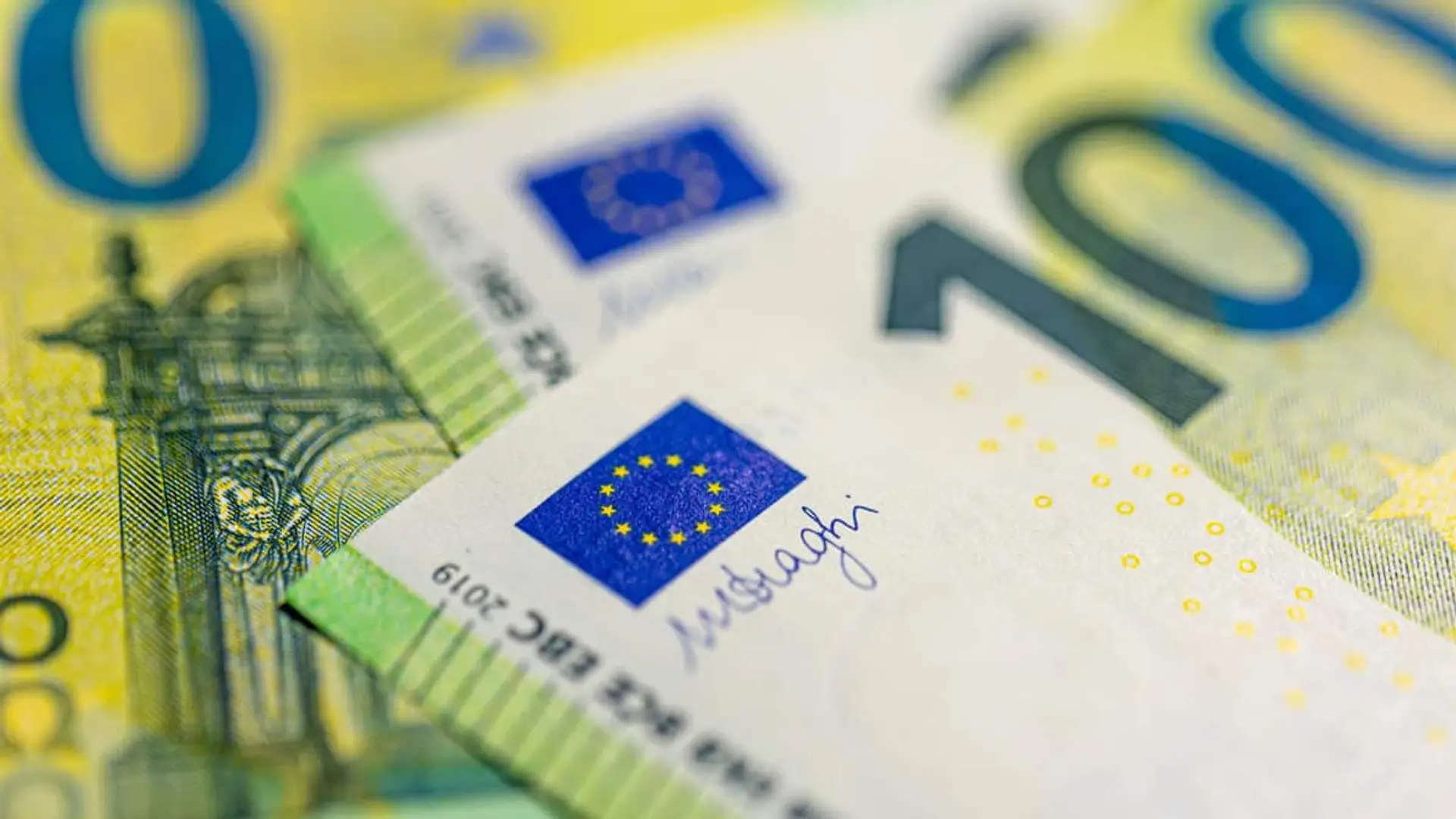 Primer plano de tres billetes de cien euros extendidos.