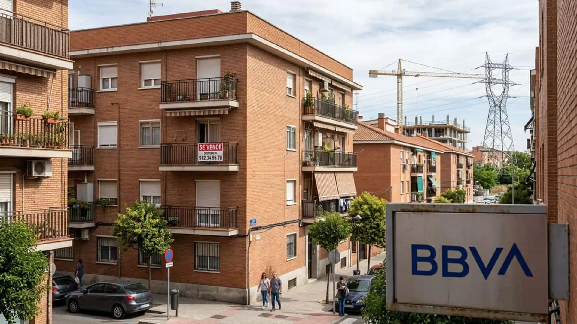 Bloques de viviendas de ladrillo con un cartel de se vende en un balcón y un letrero de BBVA en primer plano
