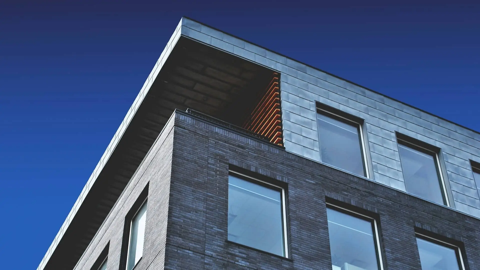 Fachada moderna de un edificio residencial con grandes ventanales.