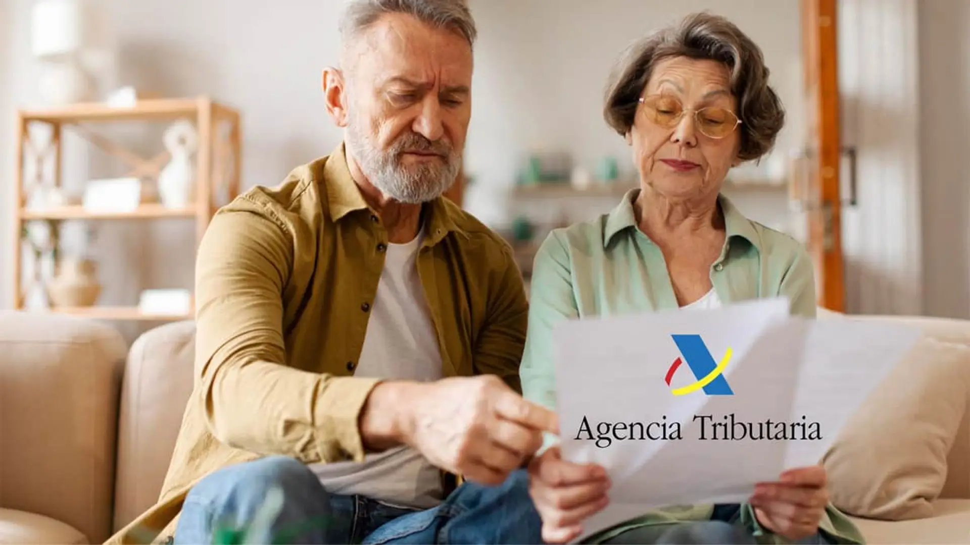 Pareja de jubilados mutualistas revisando documentos junto al logo de la Agencia Tributaria.