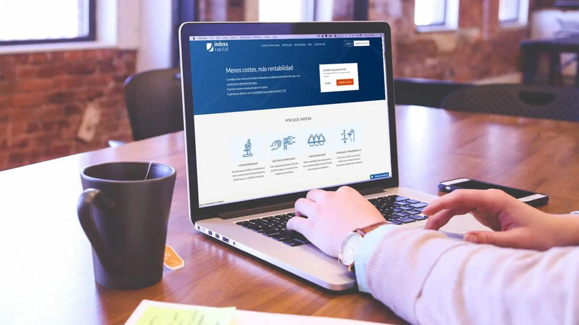 Persona utilizando un portátil con la página web de Indexa Capital abierta, sobre inversiones automatizadas.