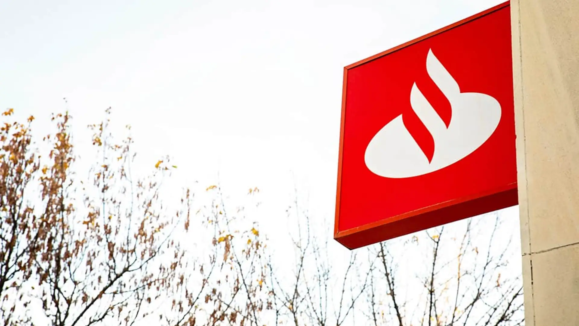 El Santander planea lanzar su stablecoin: así seguirá los pasos de Caixabank y BBVA Rótulo exterior con el logo del Banco Santander en una de sus sucursales u oficinas.