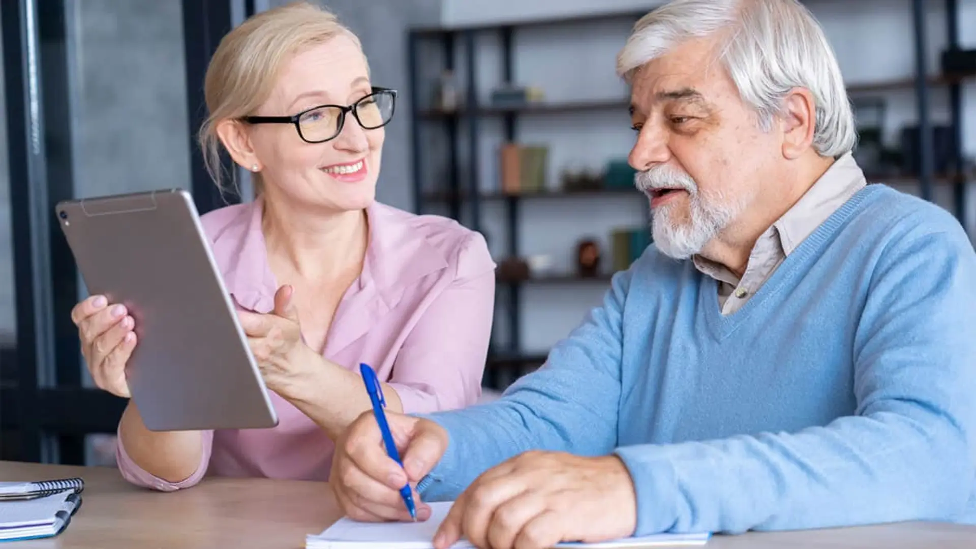 Deutsche incentiva el traspaso de planes de pensiones con una bonificación del 6% Pareja de jubilados planificando sus finanzas para la jubilación, usando una tablet para revisar su plan de pensiones.