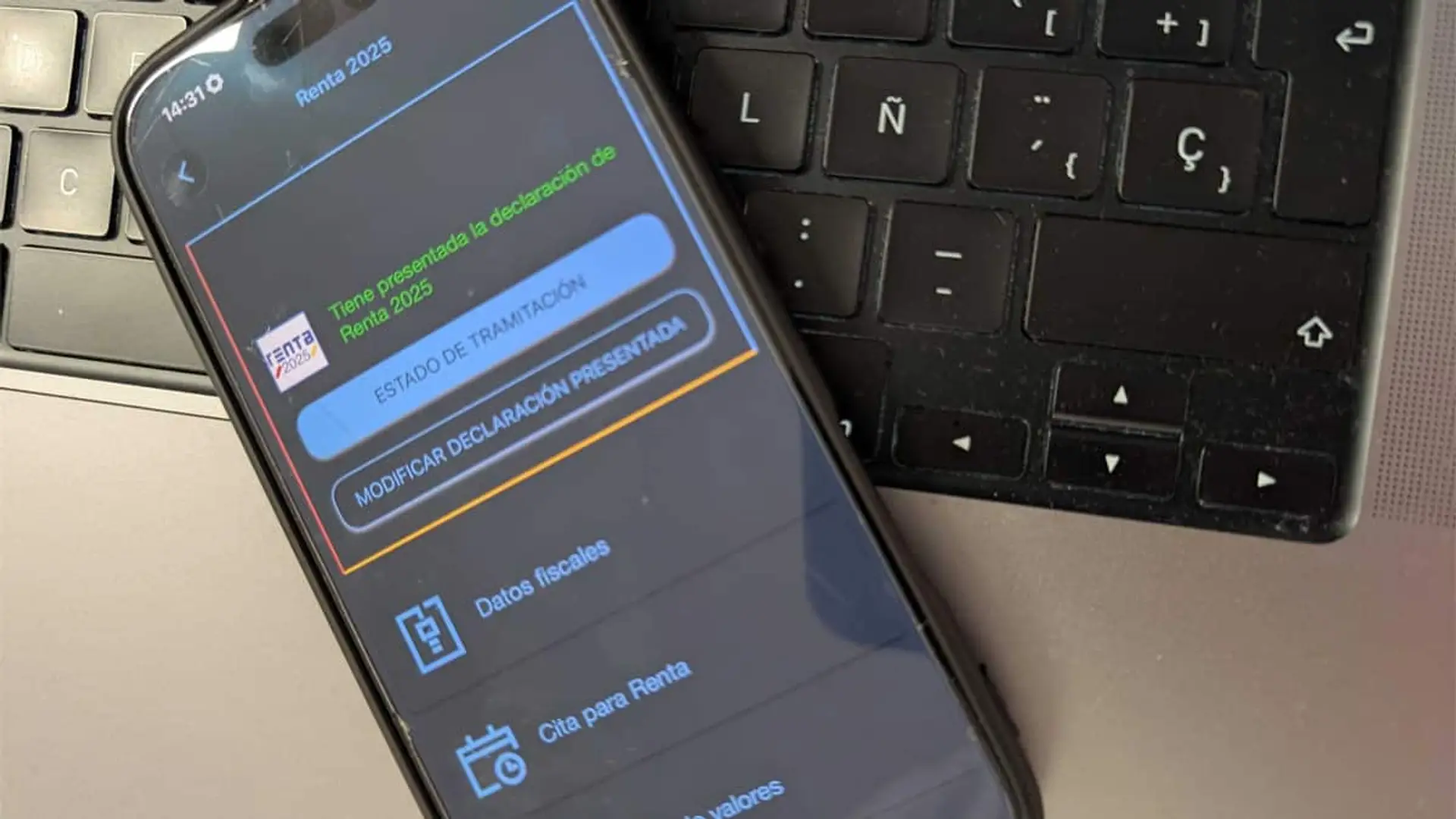 Móvil con la pantalla del estado de la declaración de la Renta 2025 presentada sobre un teclado