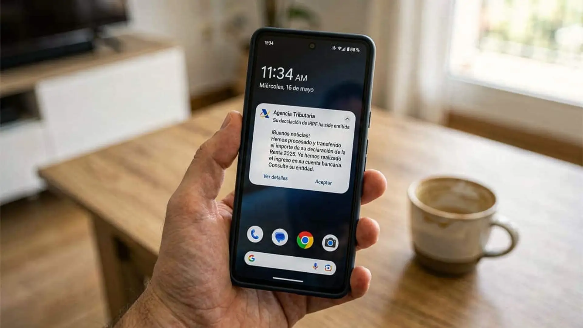 Mano sosteniendo un móvil con una notificación de la Agencia Tributaria en la pantalla