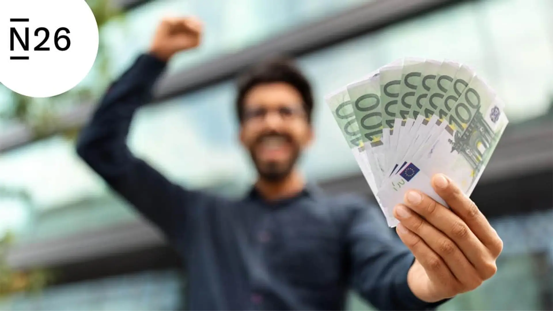 Hombre celebrando con billetes de euro junto al logotipo de N26 para representar las ventajas y ahorro en banca digital.
