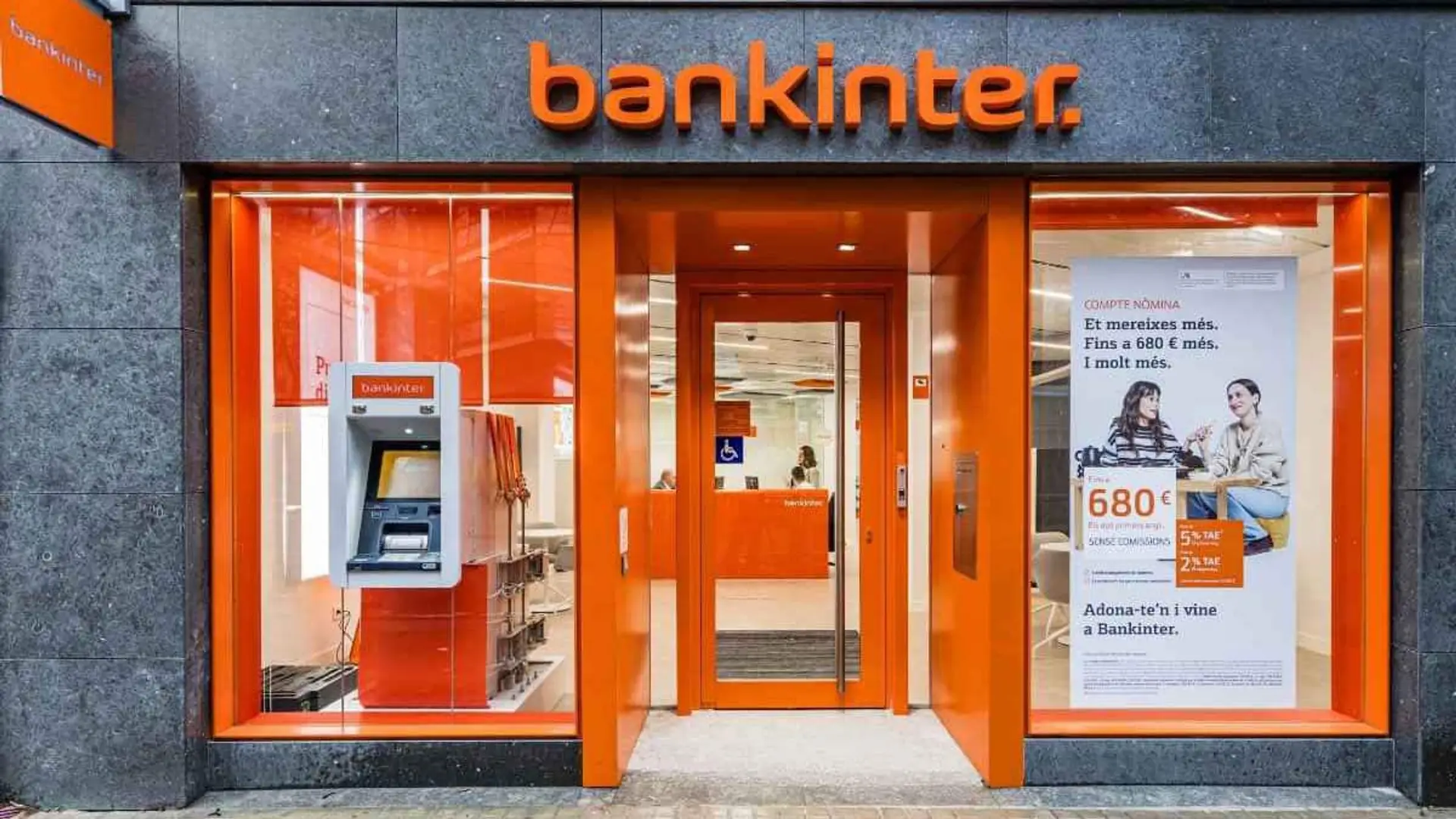 Fondos, oro e inmuebles: Bankinter refuerza su banca privada con una herramienta que integra todos los activos Entrada de una oficina de Bankinter con cajero automático y escaparate comercial