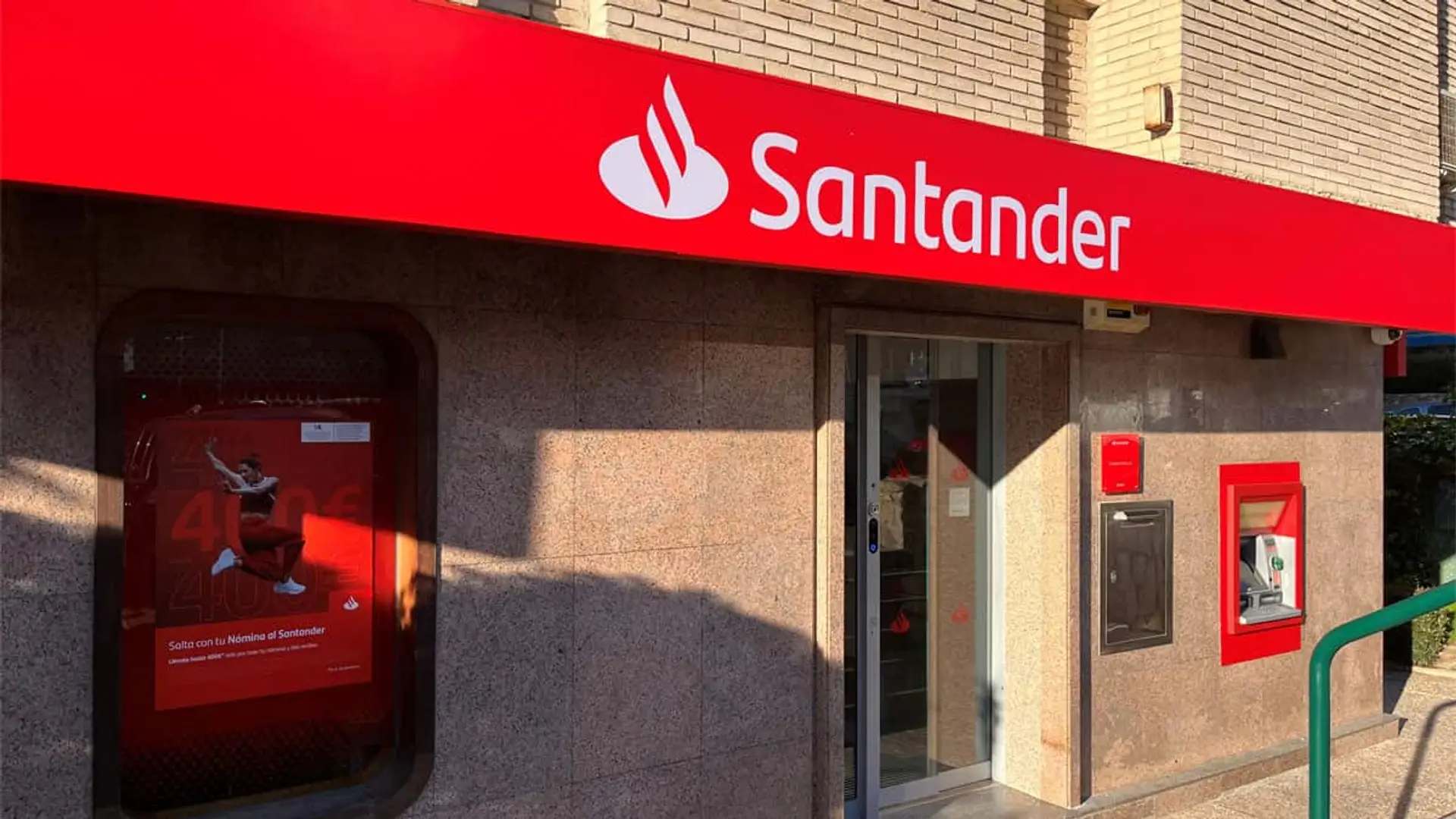 Fachada de una oficina de Santander con cajero automático y rótulo rojo