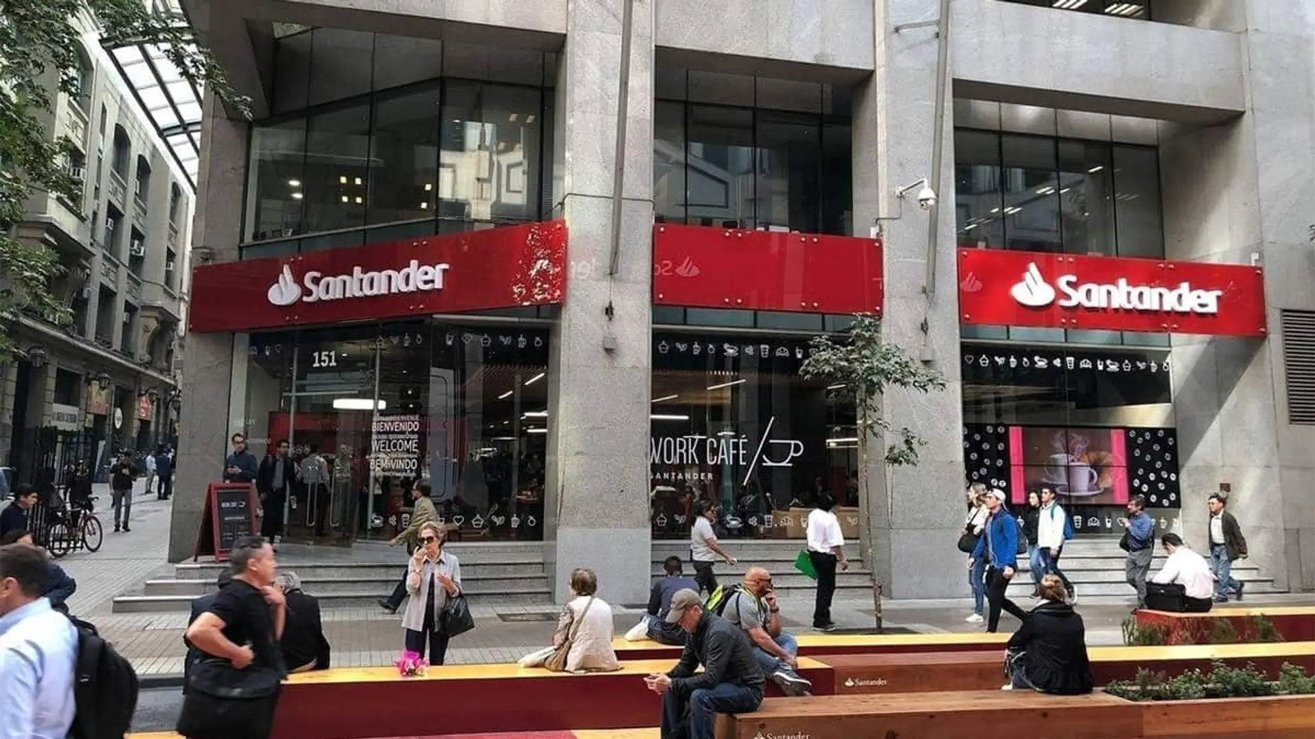 Santander acuerda con CSIF cuentas sin comisiones, préstamos al 5,5% y acceso a salas VIP para funcionarios Oficina Work Café de Santander en una calle peatonal con personas en el exterior