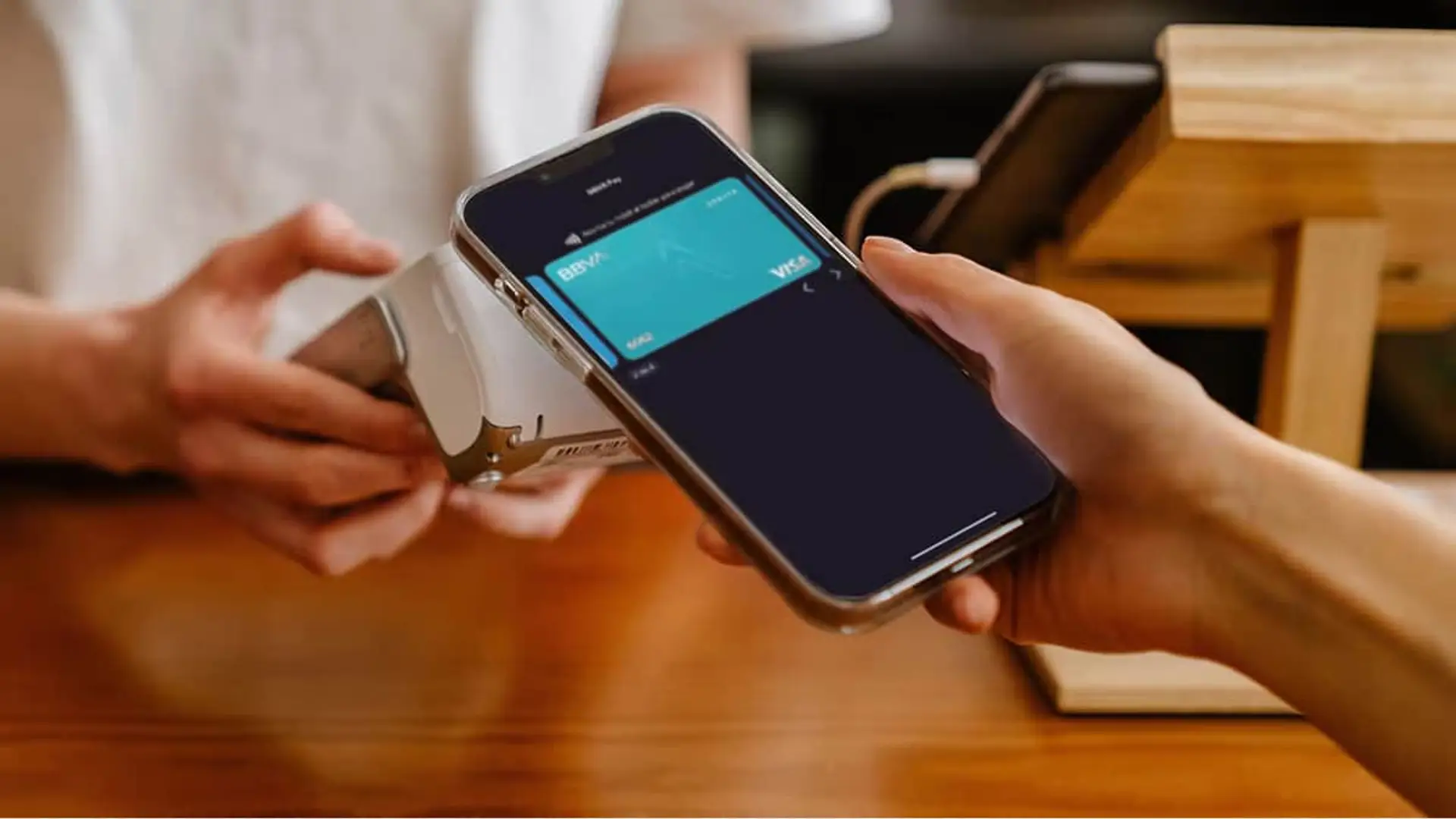 BBVA desafía a Apple y Google con su propio sistema de pagos para iPhone y Android Cliente realizando un pago contactless con su móvil y una tarjeta Visa de BBVA.