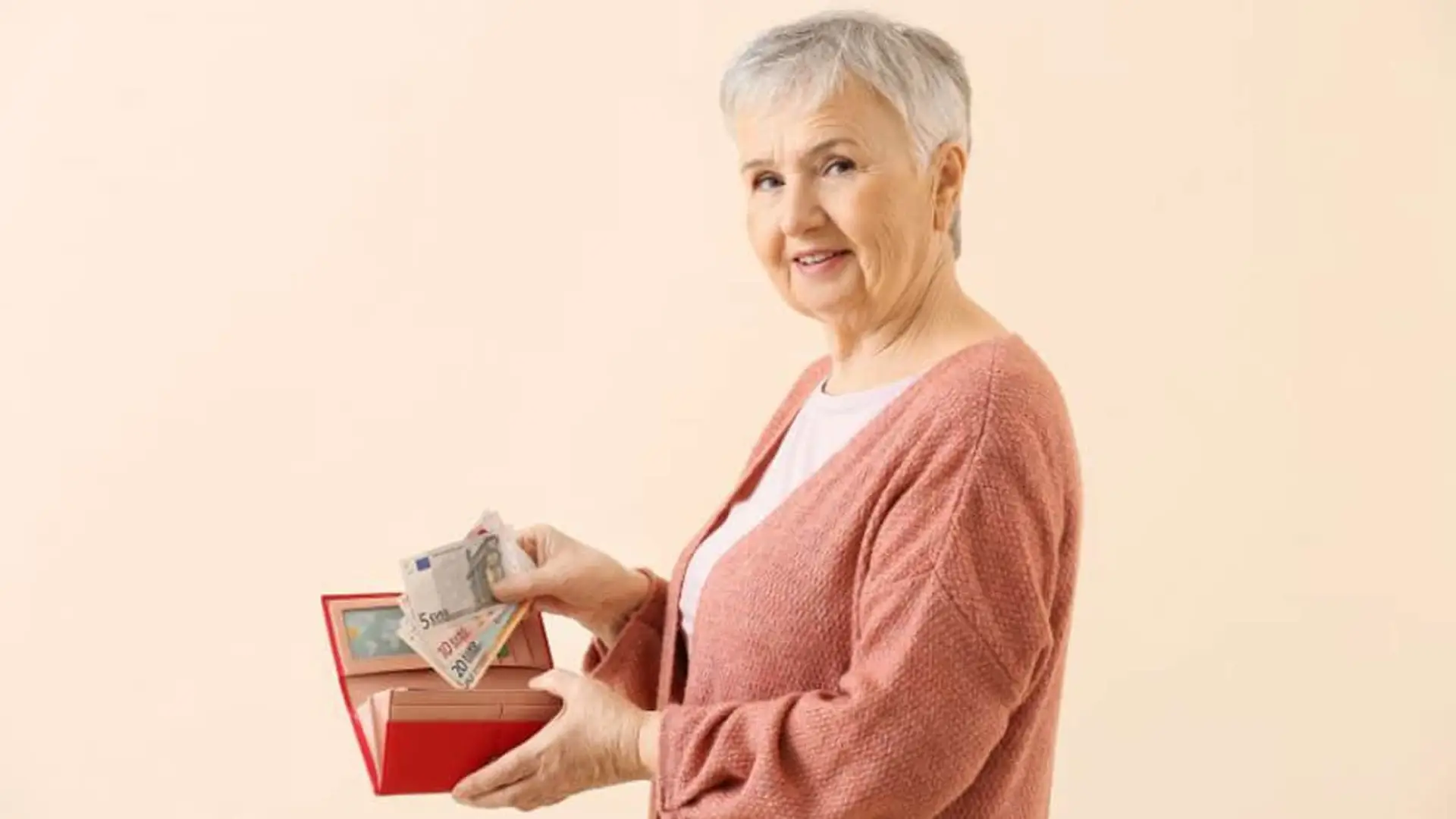 Mujer mayor sonriente gestionando sus ahorros o su pensión.