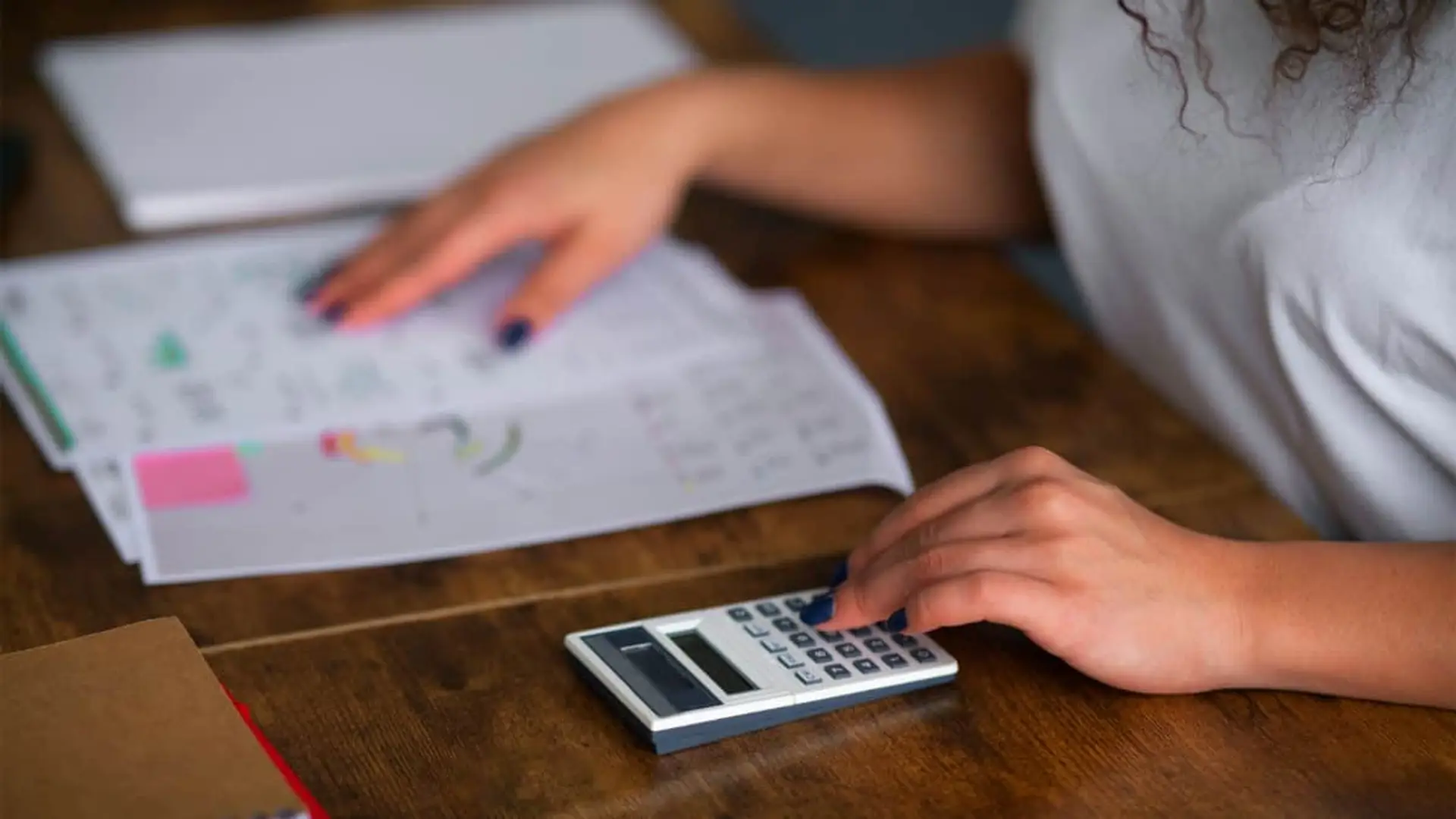 Una mujer gestiona sus finanzas personales en un escritorio.