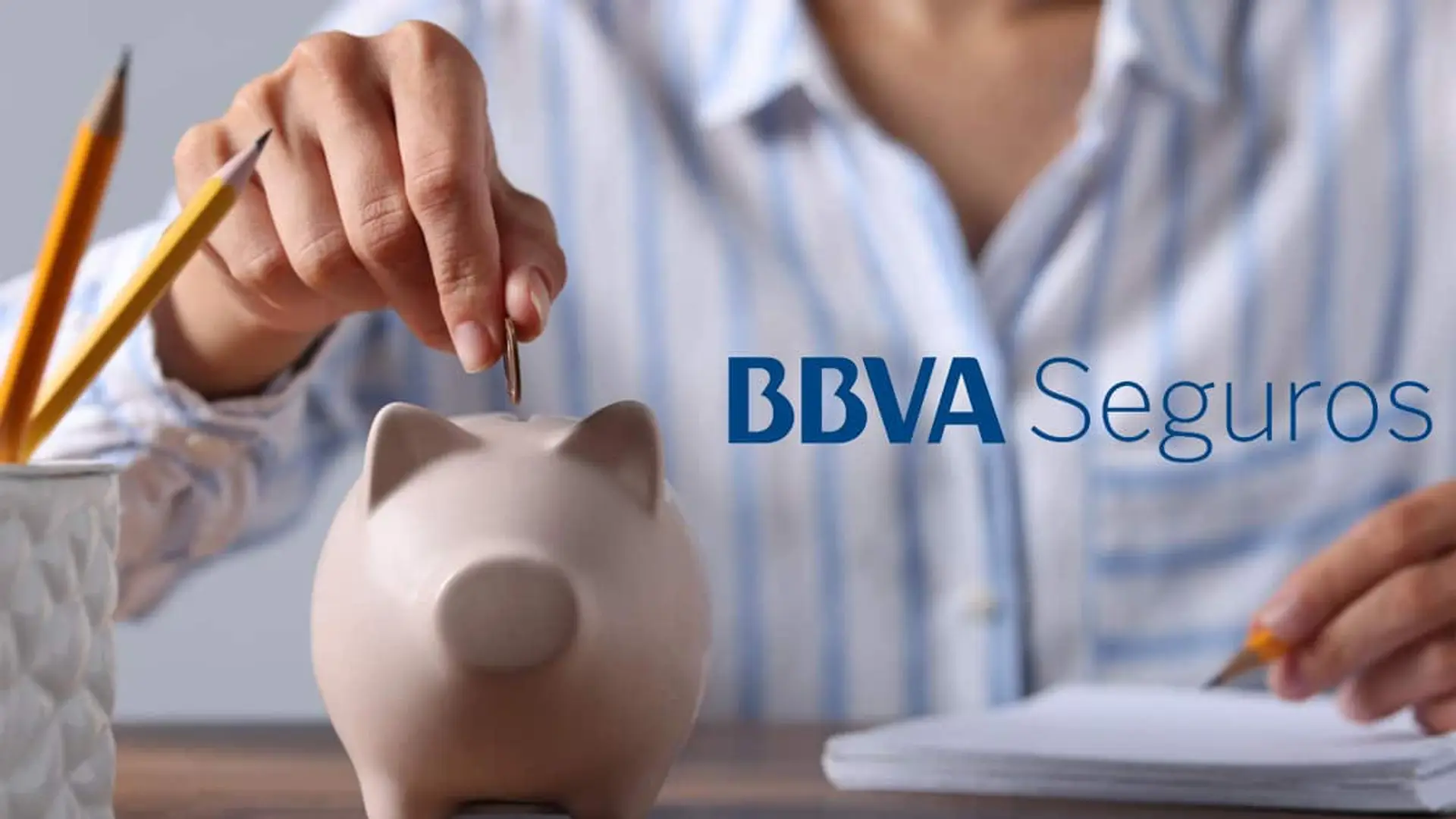 Persona metiendo una moneda en una hucha con el logotipo de BBVA Seguros sobre la imagen
