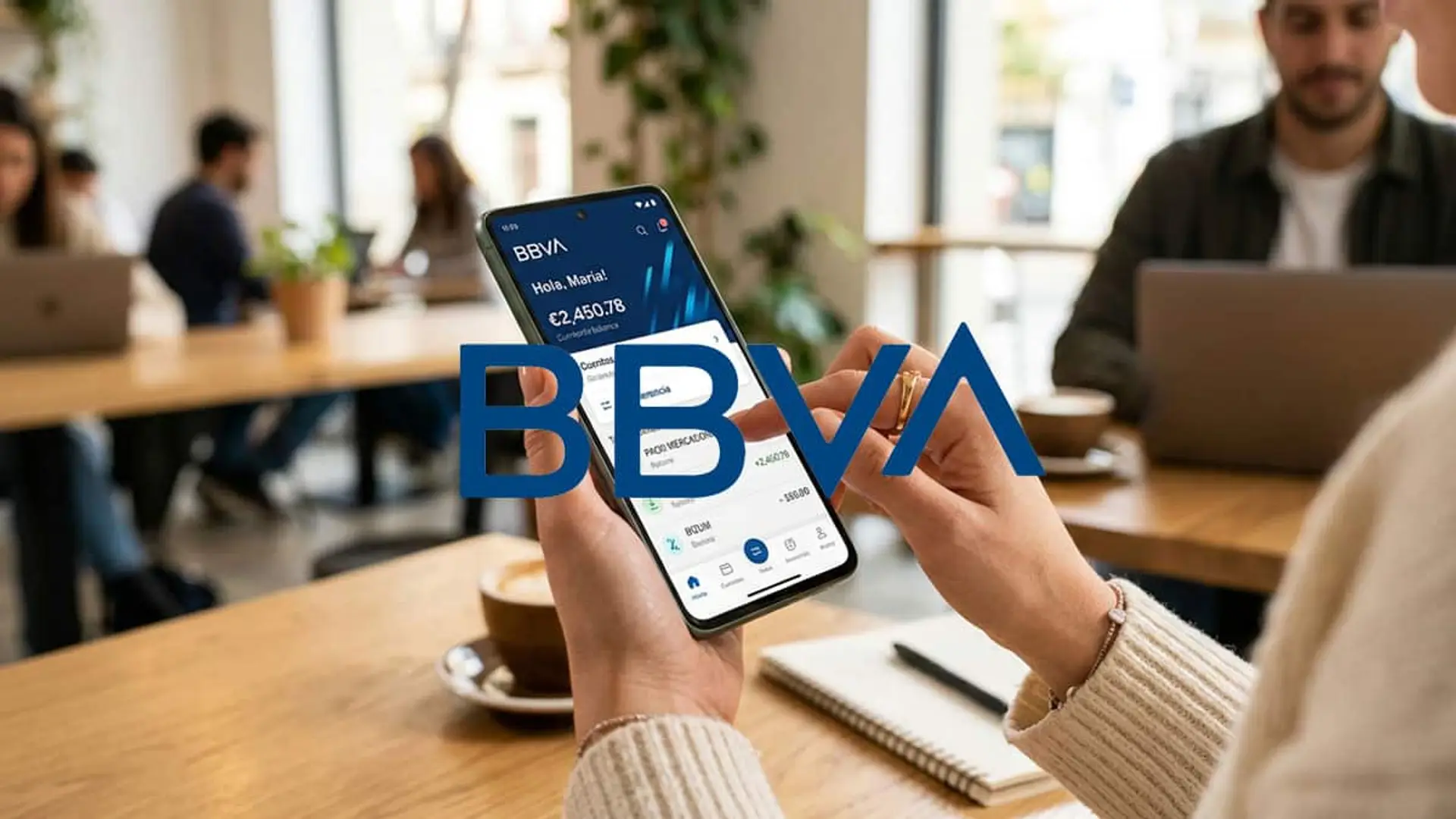 BBVA reajusta su cuenta para nuevos clientes: hasta 1.060 euros en plena guerra por la nómina Persona usando la app de BBVA en el móvil en una cafetería con el logotipo de BBVA sobre la imagen