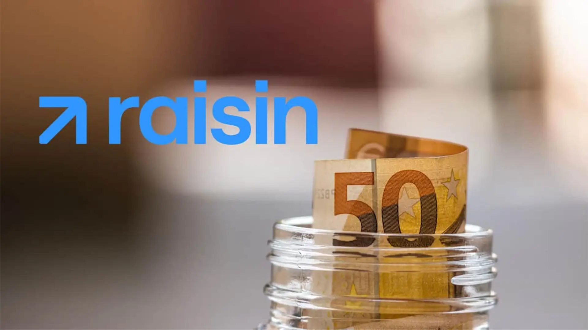 Billete de cincuenta euros en un bote de cristal junto al logo de Raisin como símbolo de ahorro y bonificación por depósito.