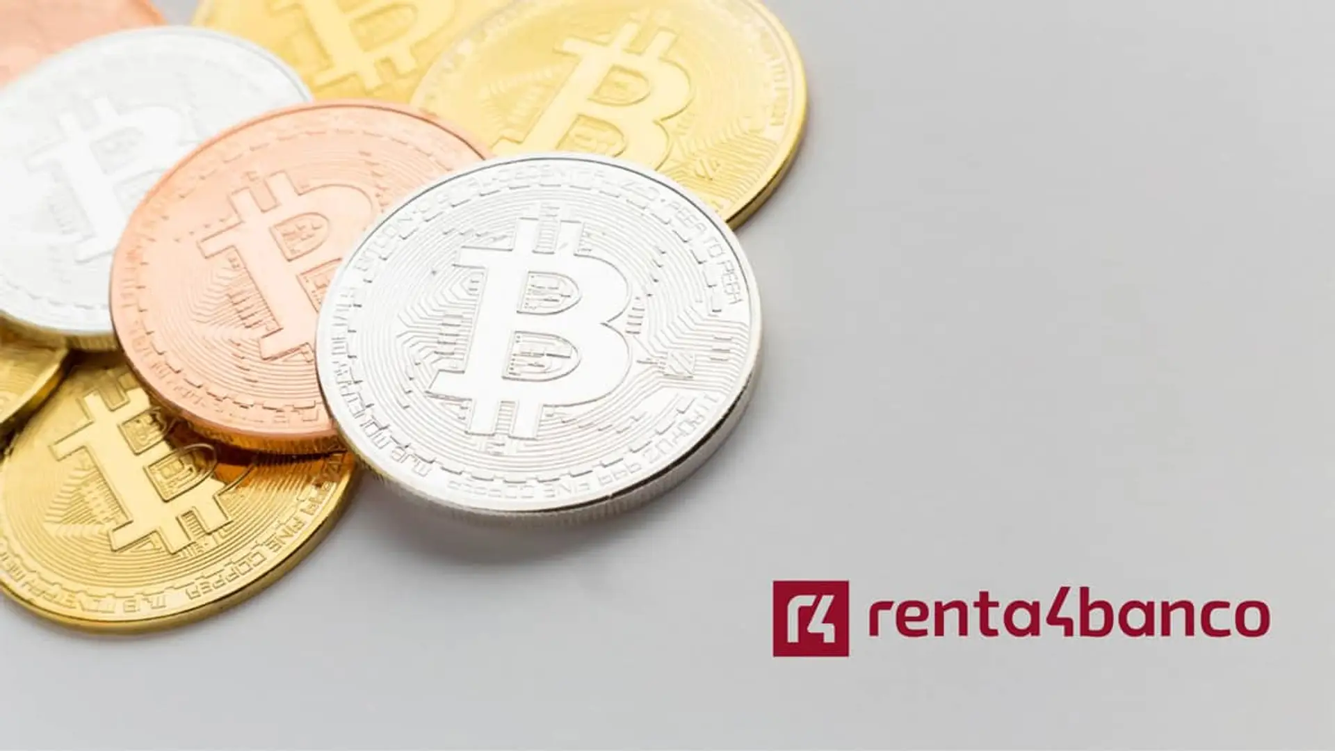 Monedas físicas de Bitcoin junto al logotipo de la entidad financiera Renta 4 Banco.