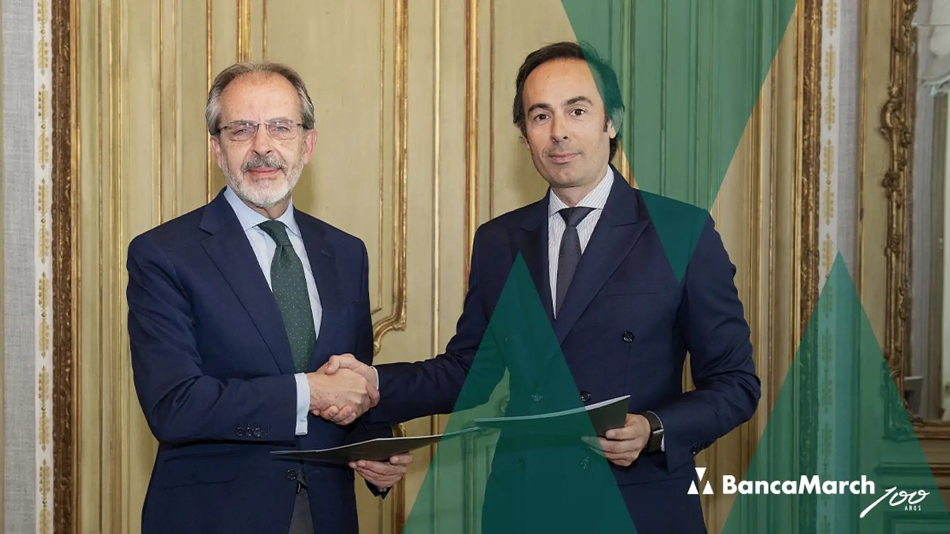 Dos representantes de Banca March y Generali estrechándose la mano mientras sostienen documentos