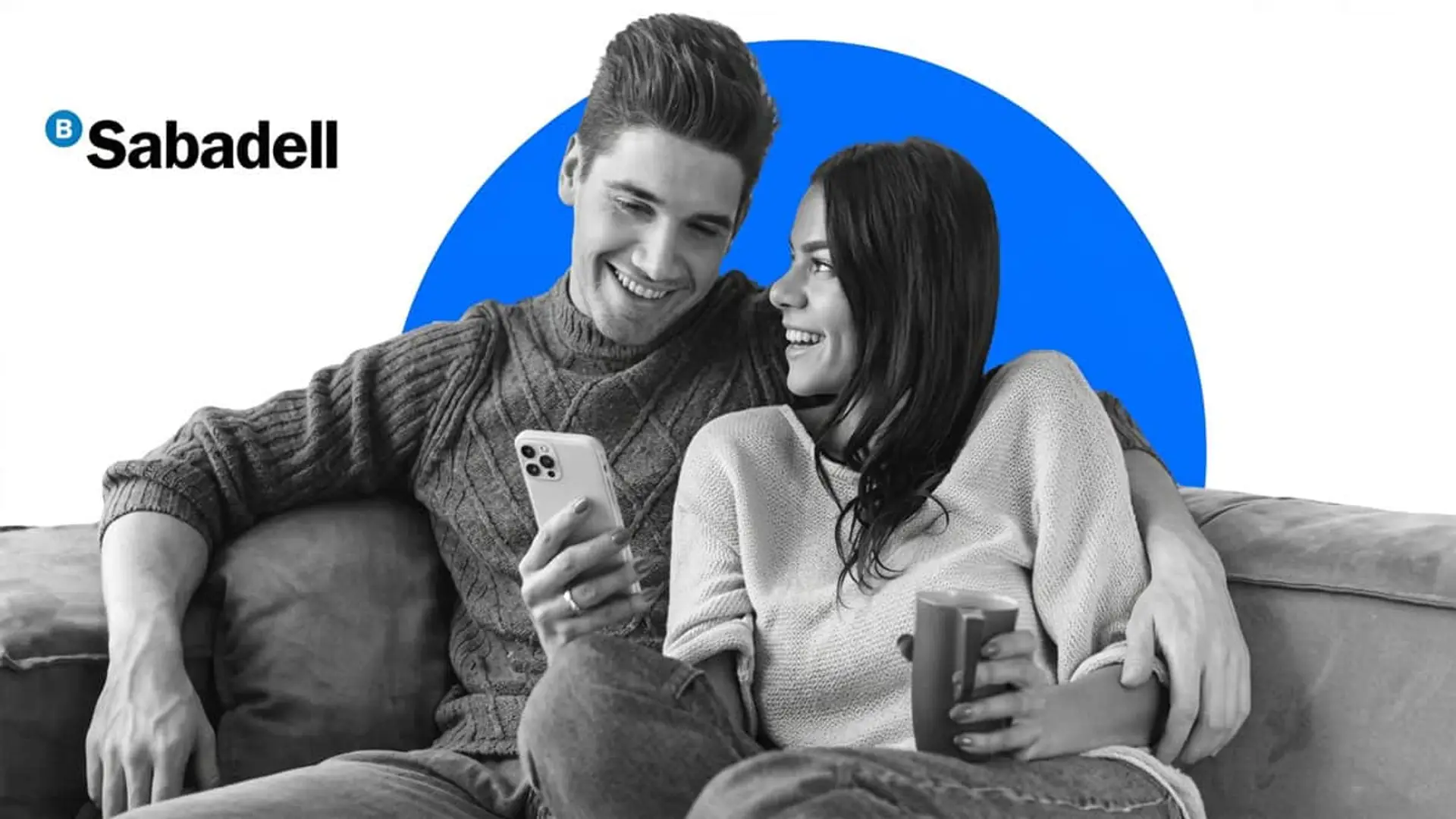 Último día: termina la promoción de la Cuenta Online de Sabadell con la que conseguir hasta 1.400€ el primer año Pareja joven gestionando su cuenta bancaria desde el móvil con el logotipo de Banco Sabadell en un ambiente de hogar.