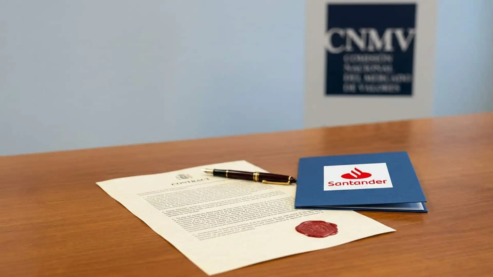 Documento contractual con sello y carpeta de Banco Santander sobre una mesa, con el logotipo de la CNMV al fondo