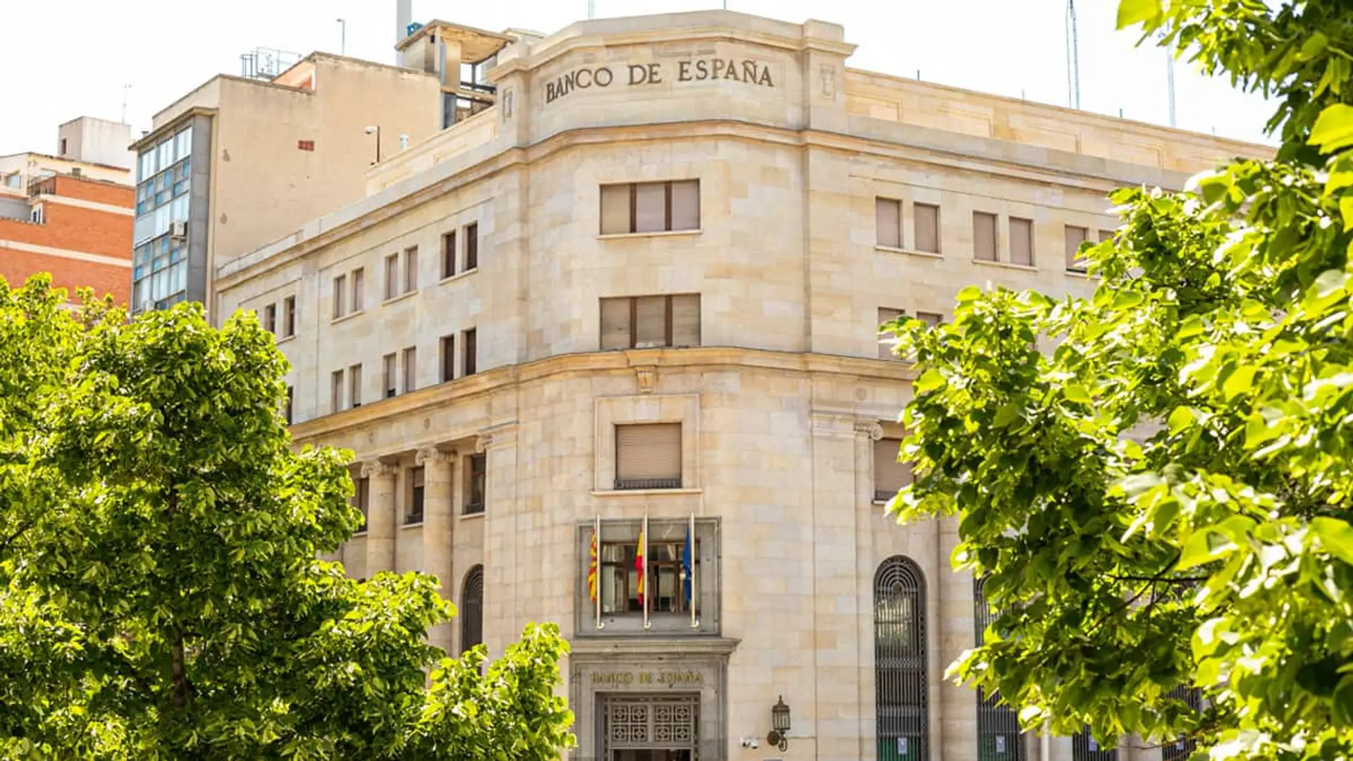 Sede del Banco de España en Zaragoza con árboles verdes a los lados.