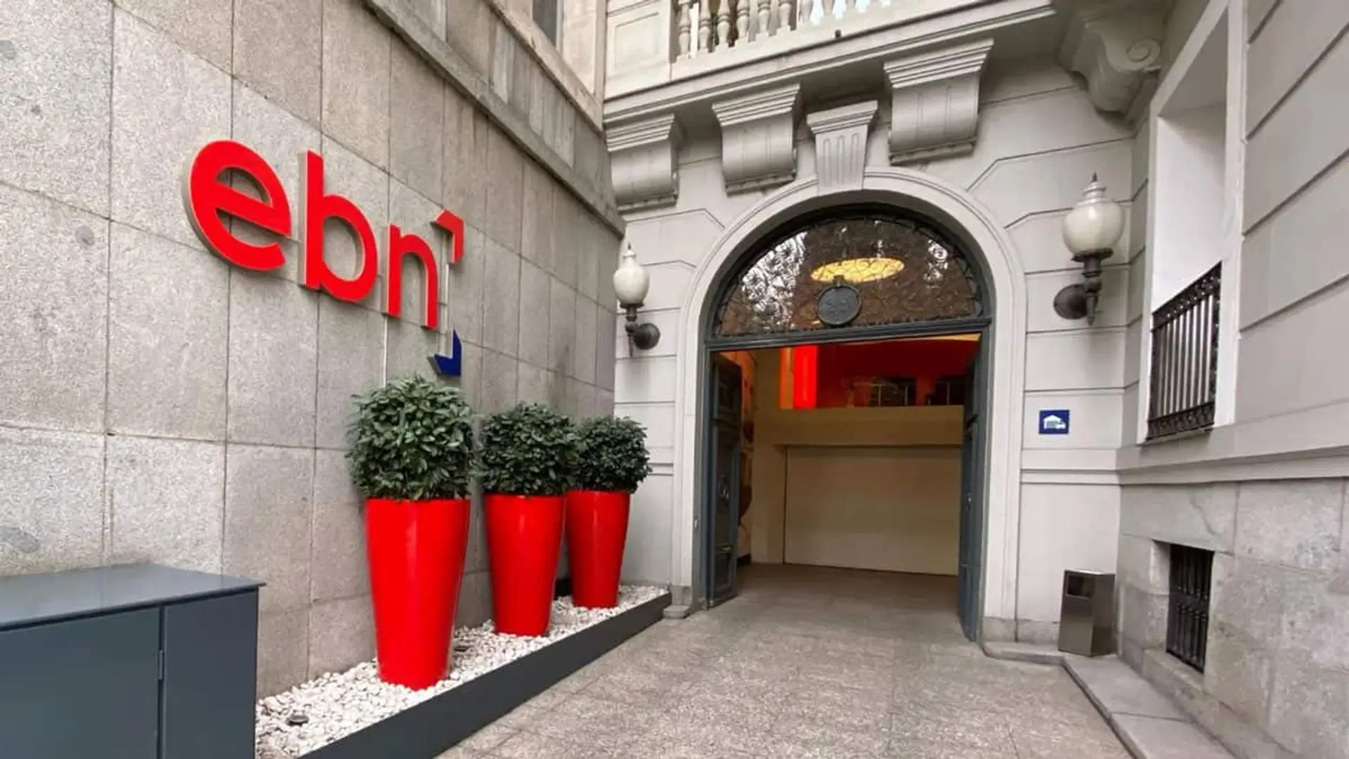 Entrada a la sede de EBN Banco con el logotipo corporativo en la fachada del edificio.