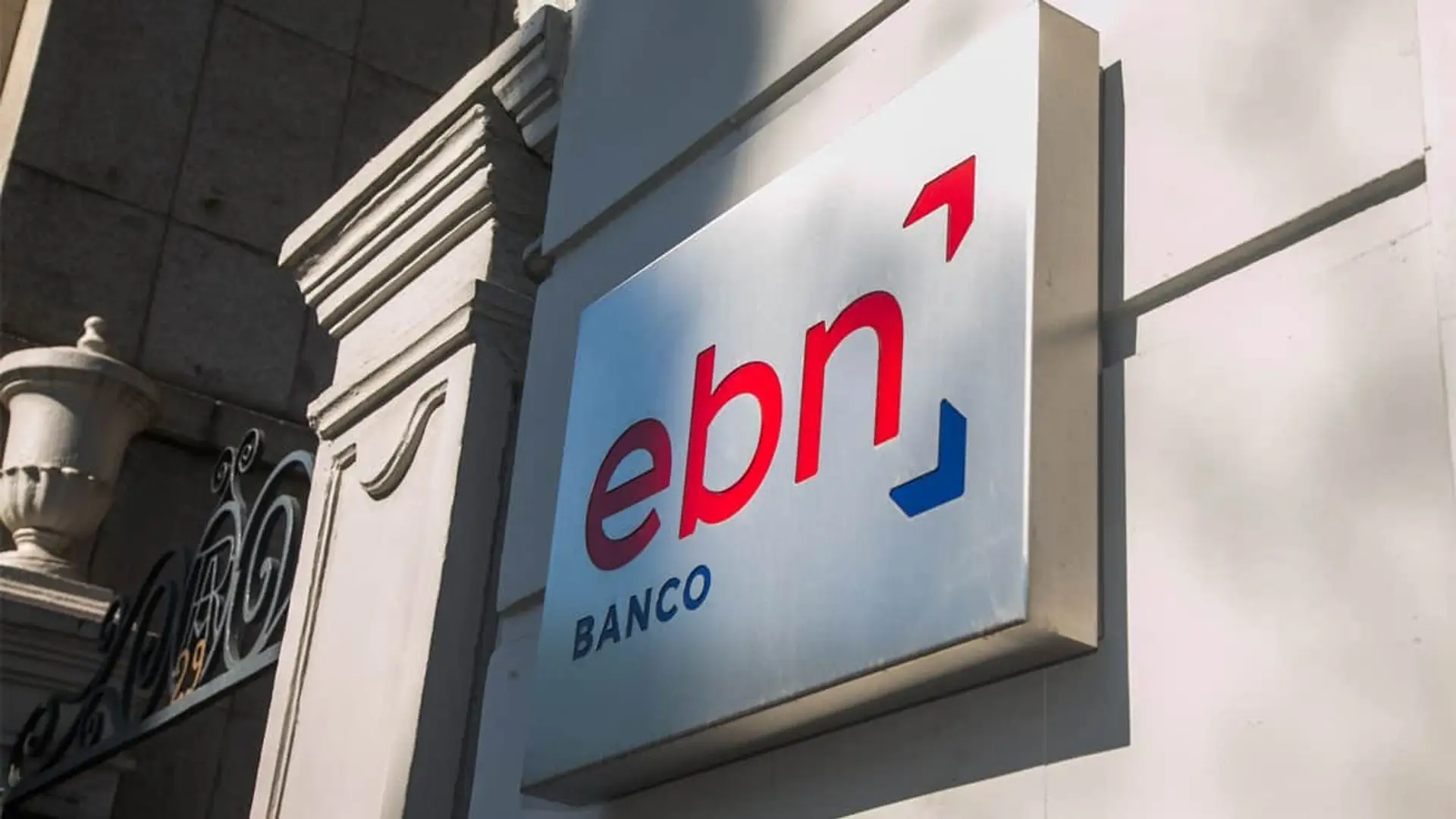 EBN Banco rompe el mercado: sube al 4% TAE la rentabilidad de su depósito a 3 meses achada de un edificio con el cartel del banco EBN en una placa metálica.