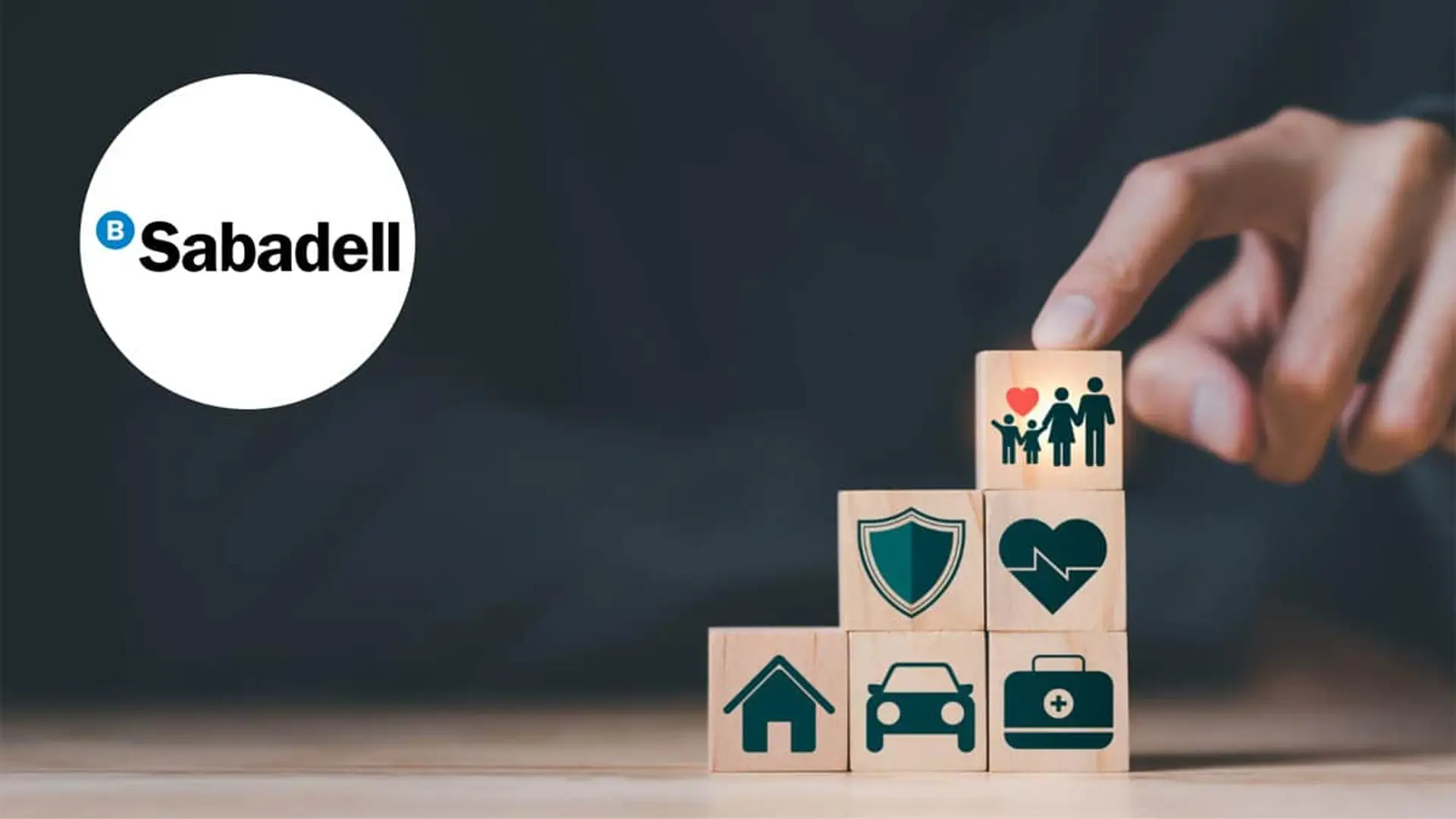 Sabadell Seguros duplica sus primas en 2025 hasta los 4.372 millones: Vida y Hogar tiran de su bancaseguros Mano apilando bloques con iconos de familia y hogar junto al logo de Banco Sabadell para representar planes de seguros.