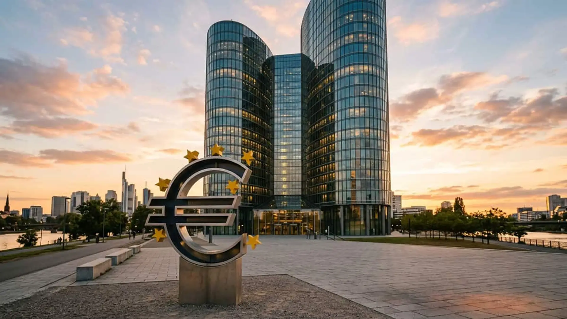 Escultura con el símbolo del euro frente a un edificio de oficinas del Banco Central Europeo al atardecer