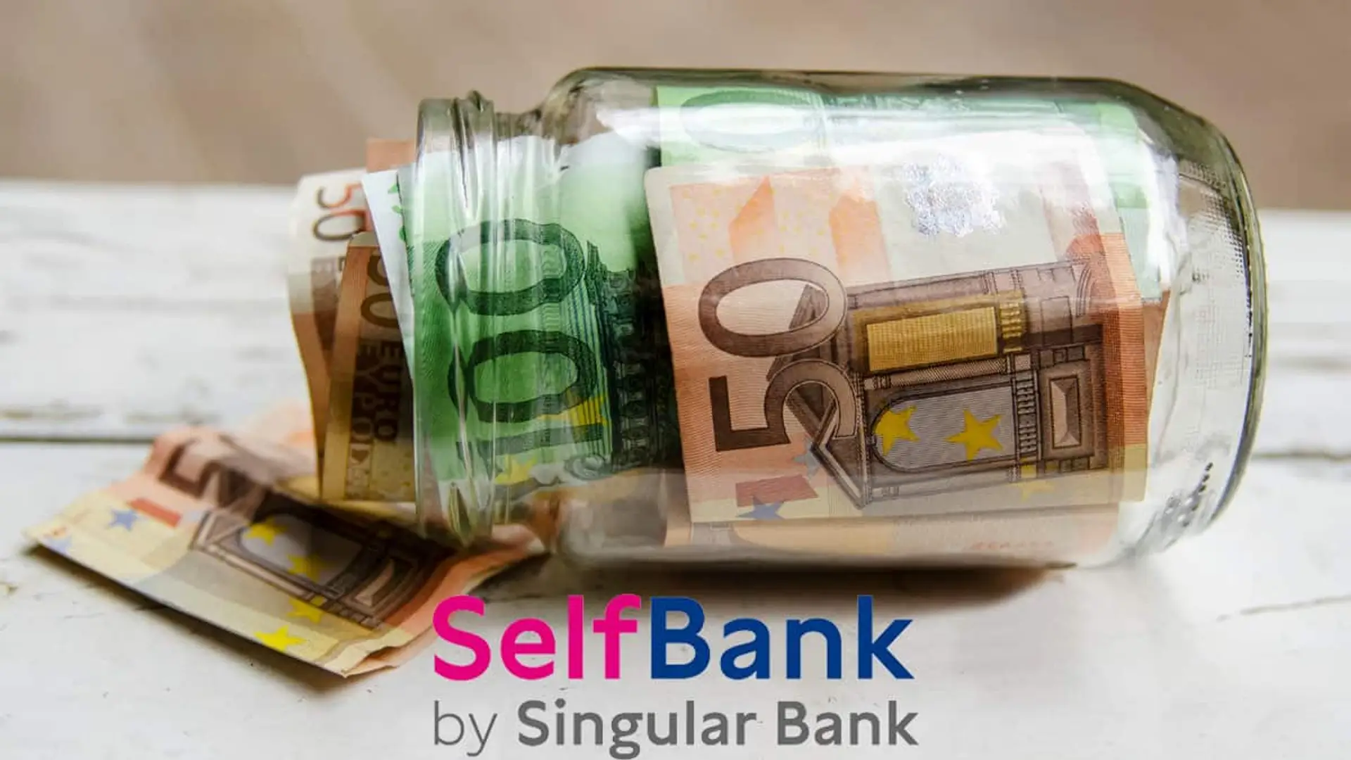 Tarro de cristal con billetes de euro y el logotipo de Self Bank by Singular Bank