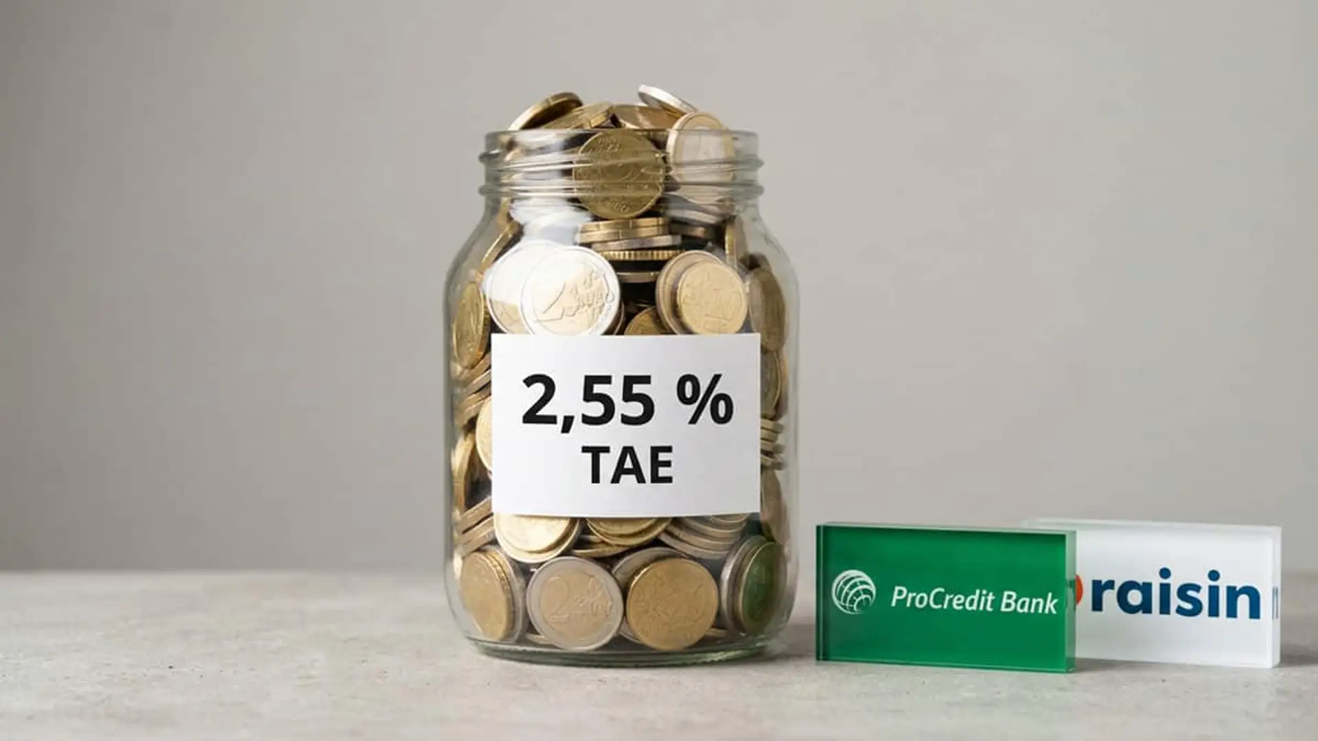 Tarro de cristal lleno de monedas con una etiqueta del 2,55 % TAE junto a los logotipos de ProCredit Bank y Raisin