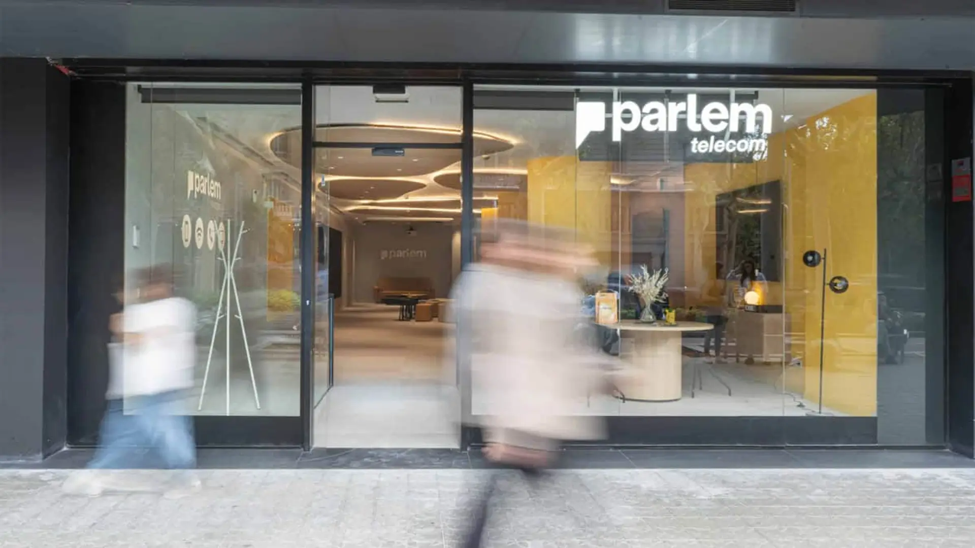 Fachada de una tienda física de Parlem Telecom con diseño moderno y logotipo corporativo en la cristalera.