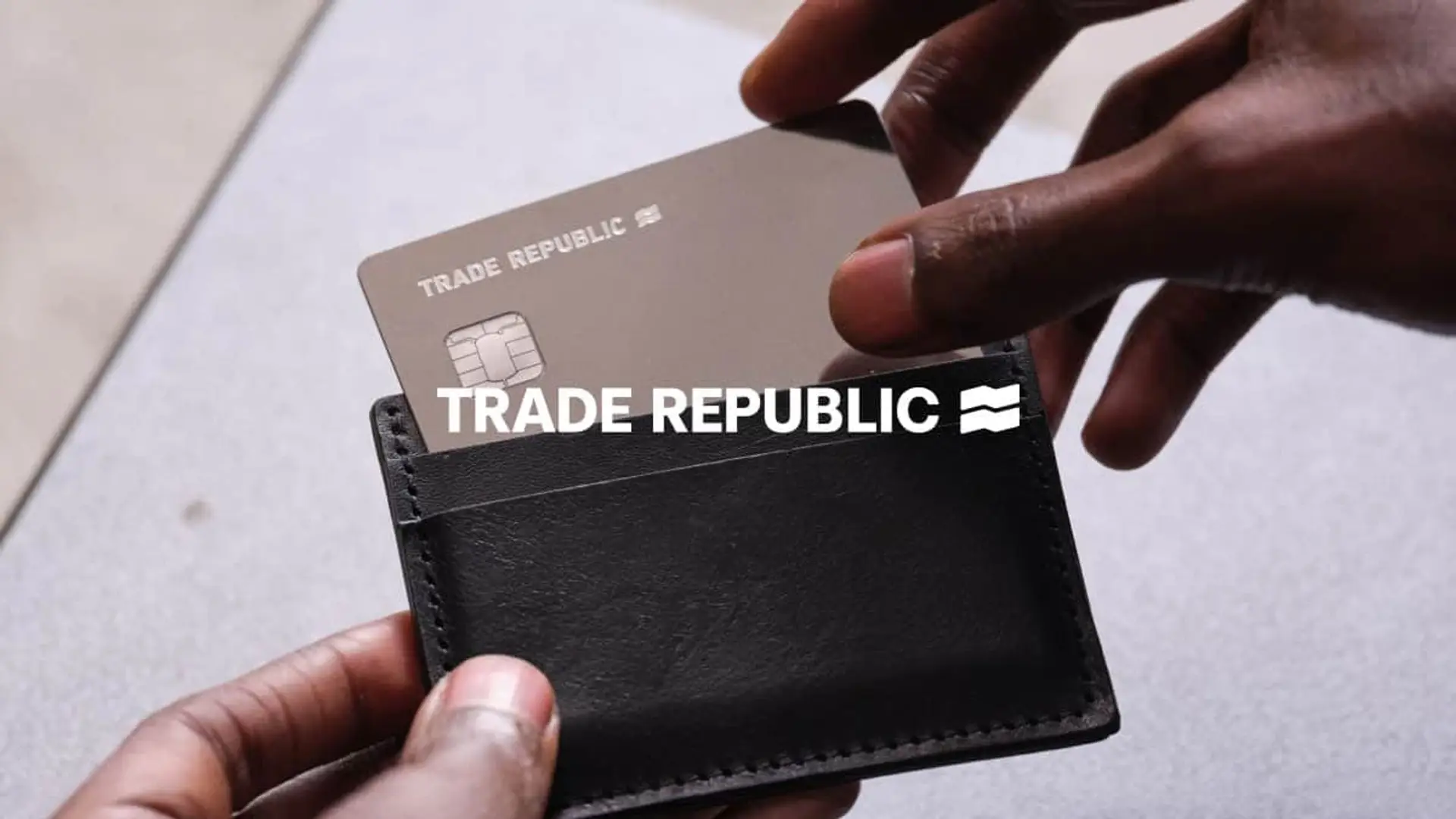 Tarjeta Trade Republic metálica en tarjetero negro para ahorro e inversión con el logotipo de la marca.