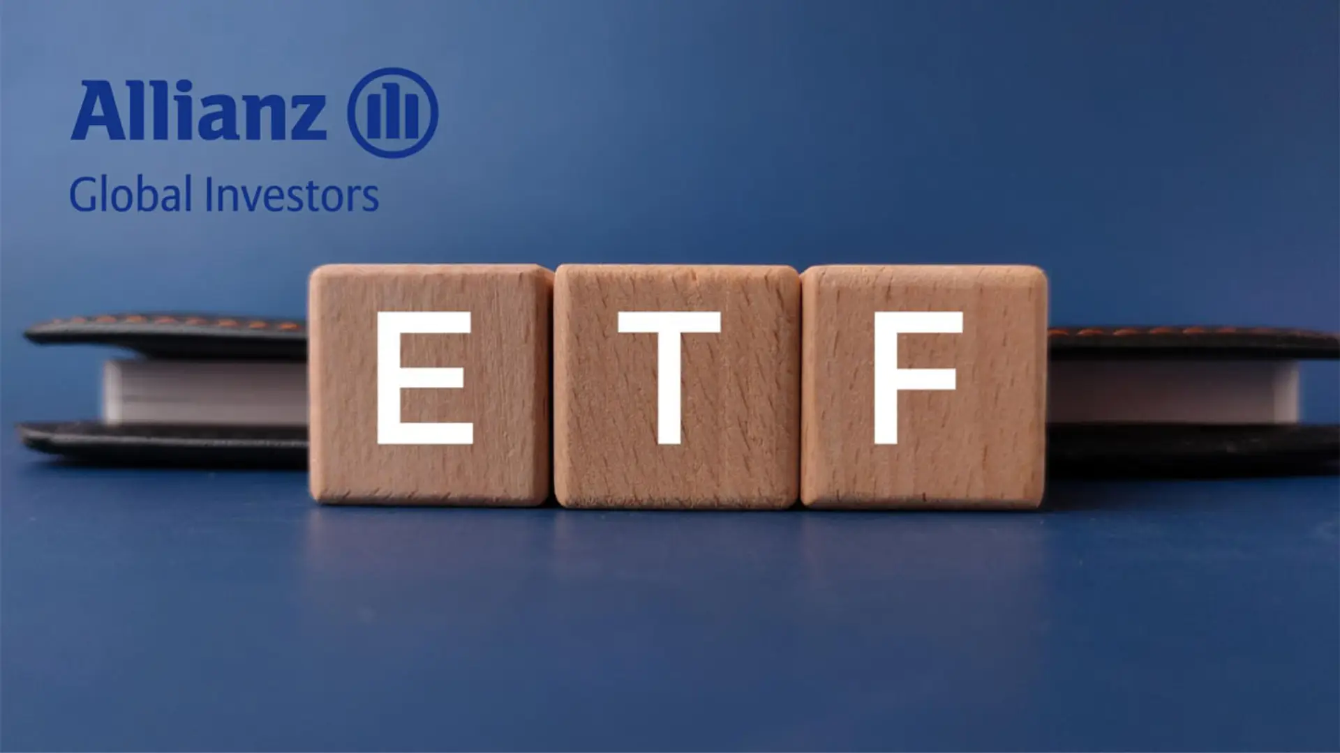 Logo de Allianz Global Investors y bloques de madera con las siglas ETF para inversión en fondos cotizados.