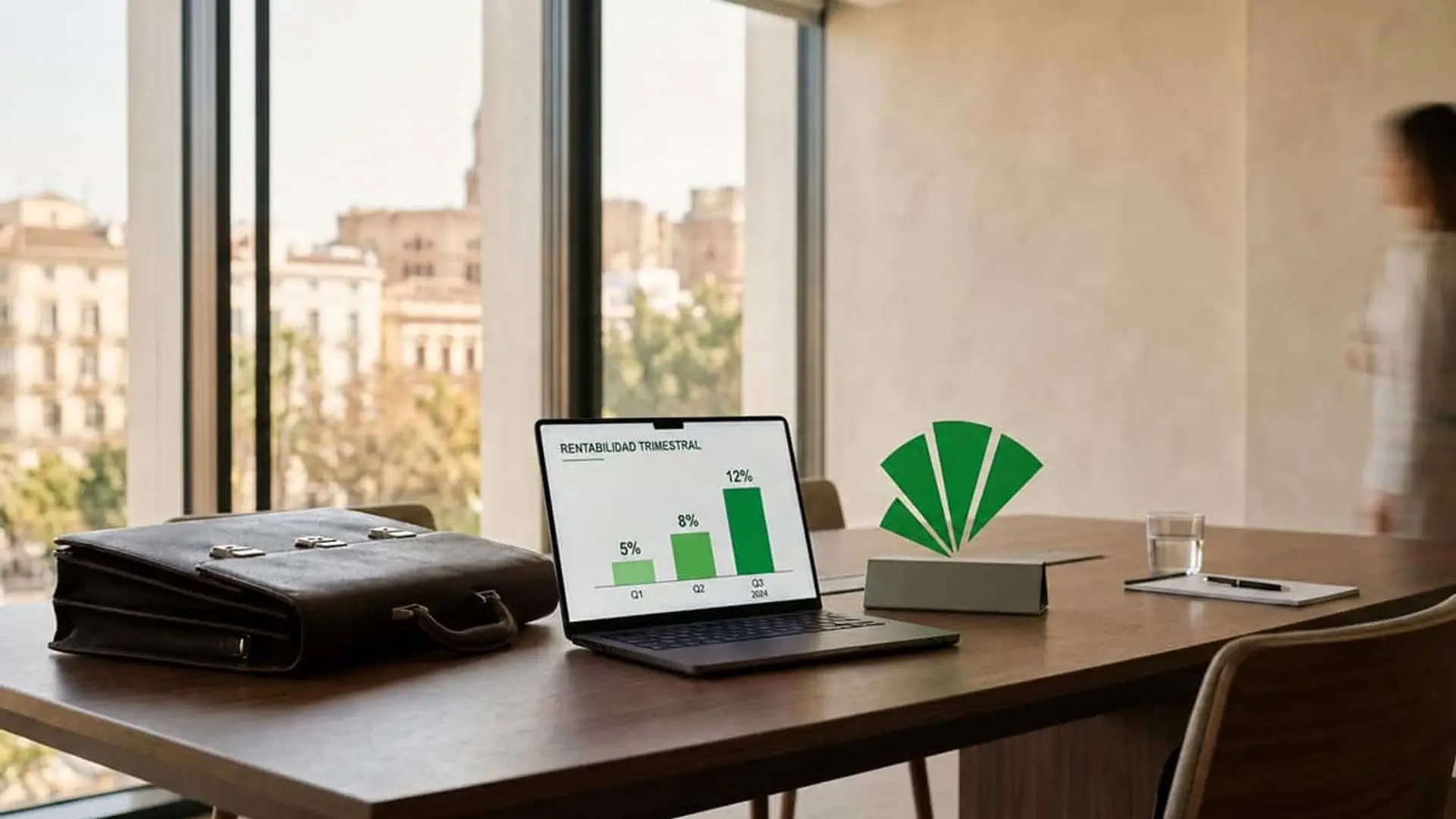 Unicaja logra 361 millones de beneficio (+7,1%) y ficha a Cienfuegos, ex Sabadell, para banca de empresas Logotipo de Unicaja junto a un ordenador con un gráfico de rentabilidad trimestral y un maletín en una sala de reuniones