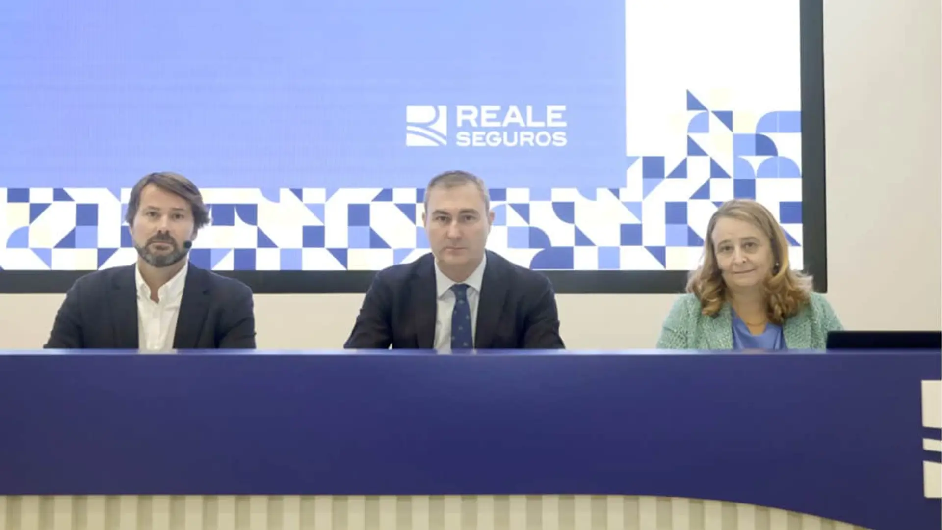 Directivos de Reale Seguros en una mesa de ponencias durante un evento corporativo de la aseguradora.