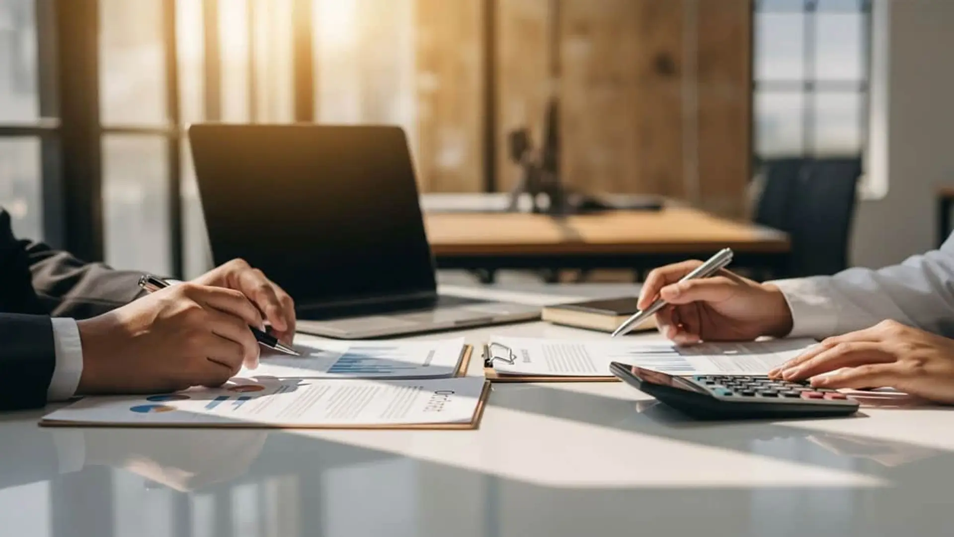 El seguro marca un nuevo récord de ingresos con más de 64.000 millones en primas Dos profesionales en una reunión de contabilidad calculando los beneficios del sector asegurador.