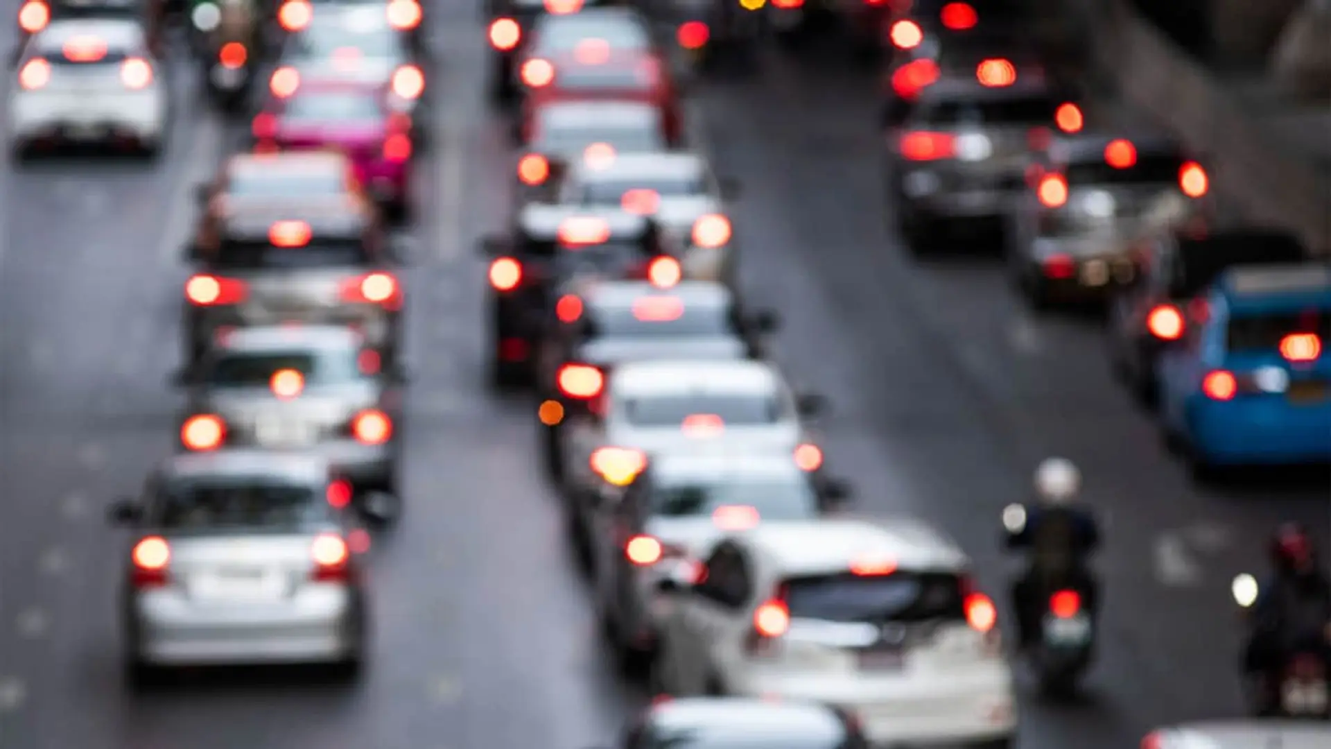 Más de 34 millones de coches asegurados: no se veía un crecimiento así desde 2019 Tráfico denso en una avenida con numerosos vehículos y luces traseras encendidas.