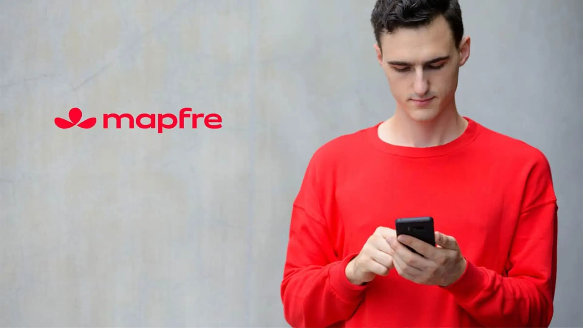 Joven usando su smartphone junto al logo de Mapfre para representar el servicio de avisos meteorológicos y prevención.